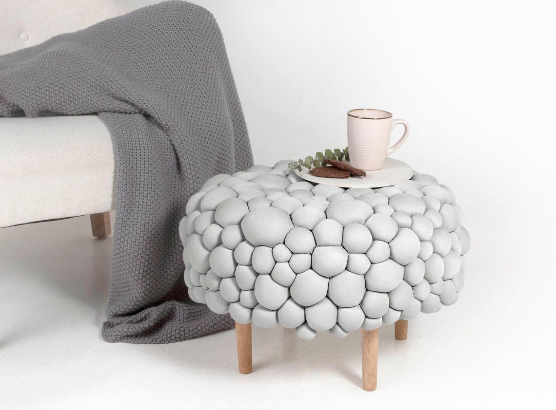 A small footstool or side table with a stone-like exterior.