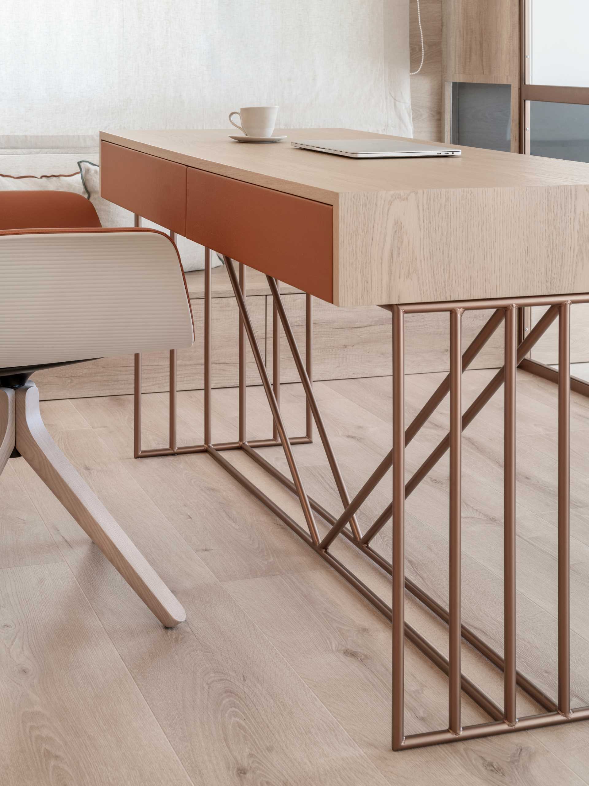 A modern desk with an oak top and copper legs.