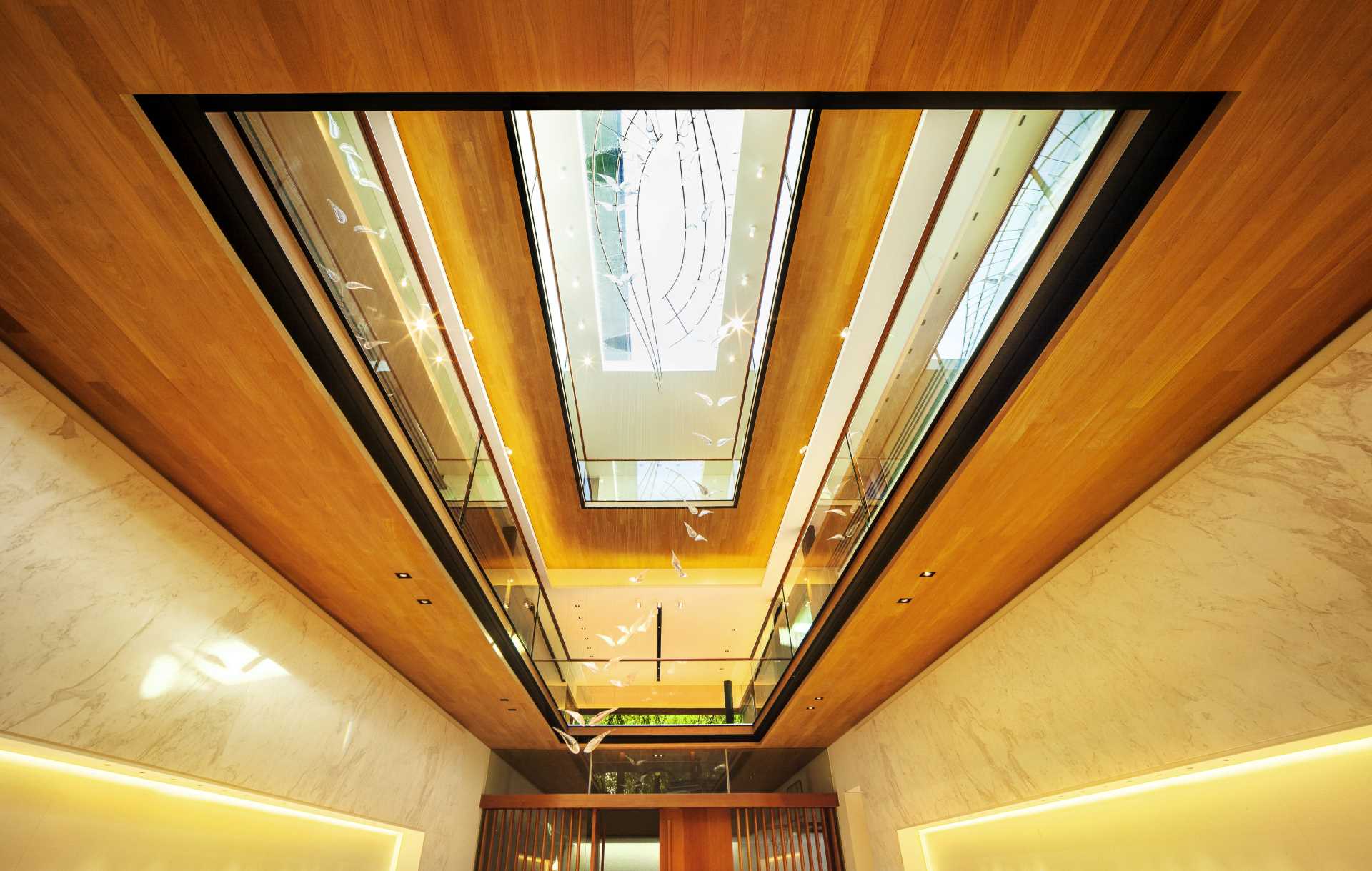 This modern house has a light filled central court with a glass window to the floor of the attic swimming pool which fills the house with light.