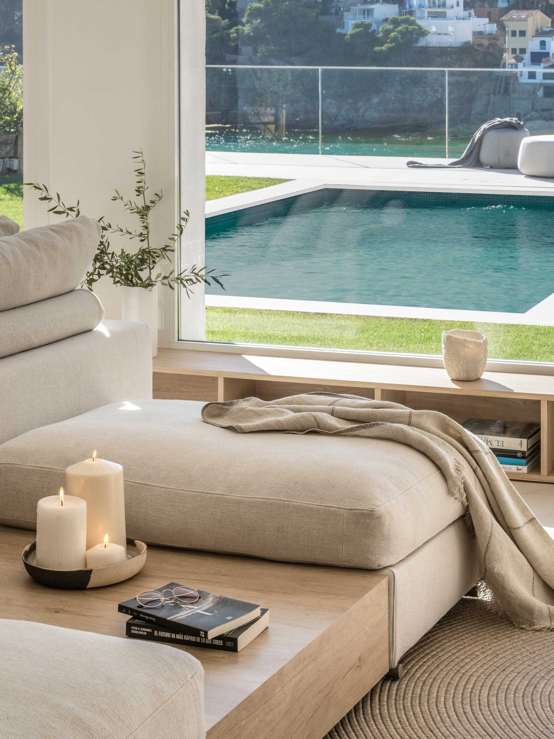 A modern living room with a double-sided couch, and a storage unit that runs underneath the windows.