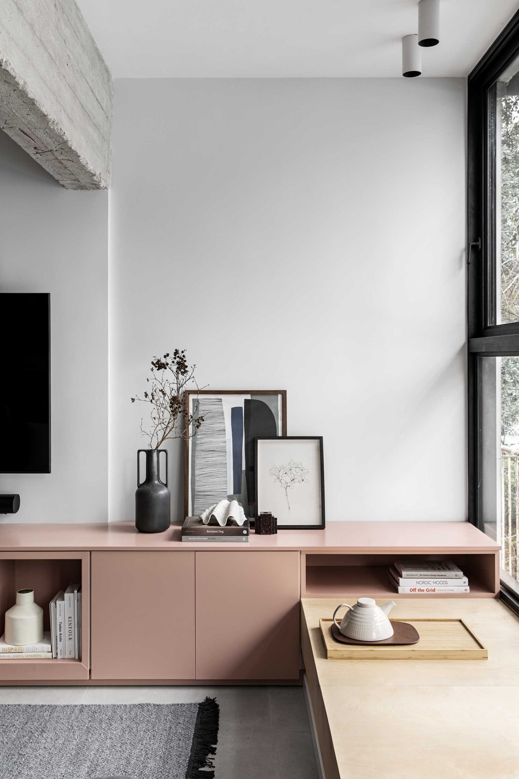 A modern living room with built-in cabinetry and wood window bench.