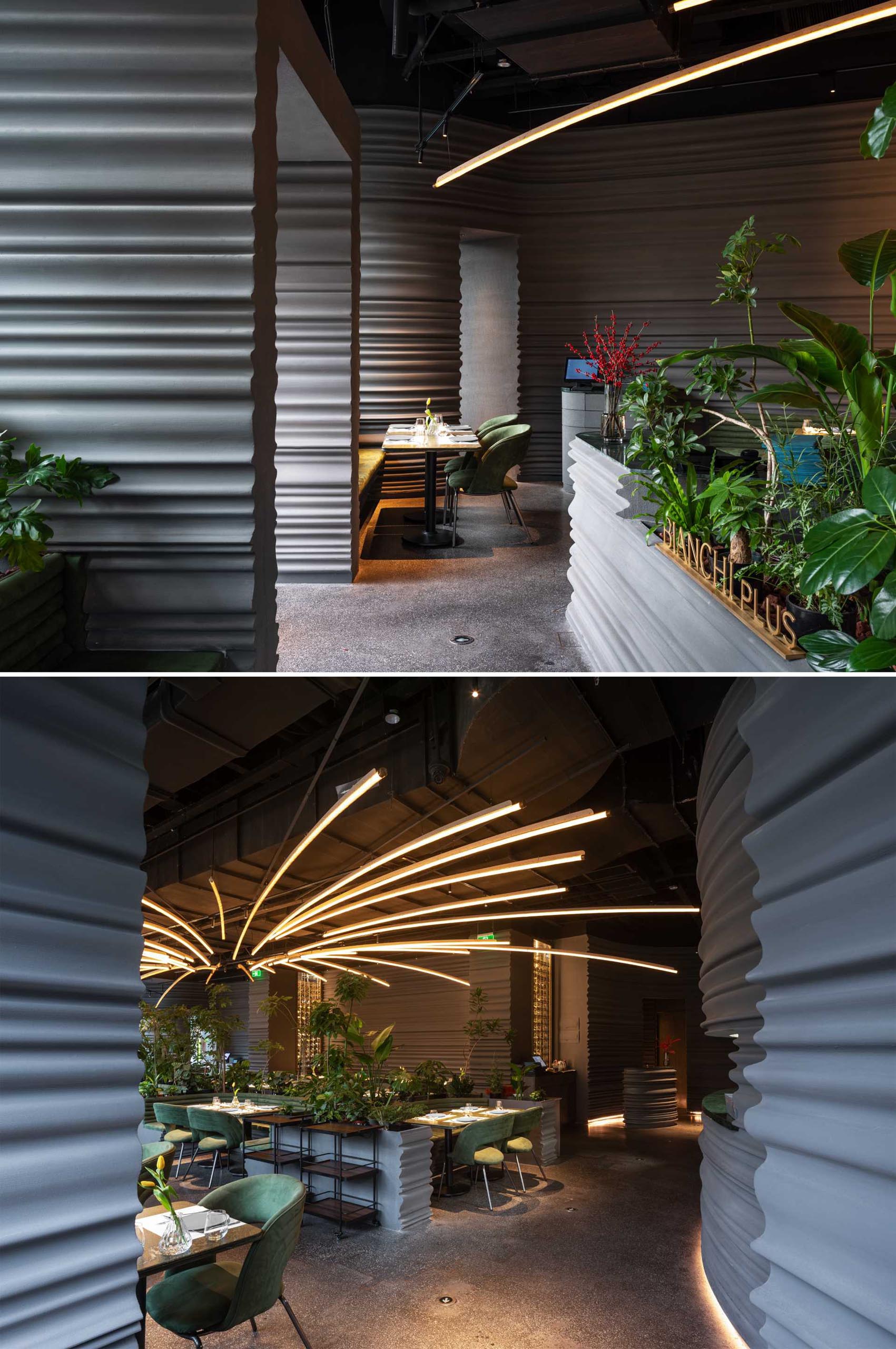 A modern restaurant with sculptural gray walls and plenty of plants.