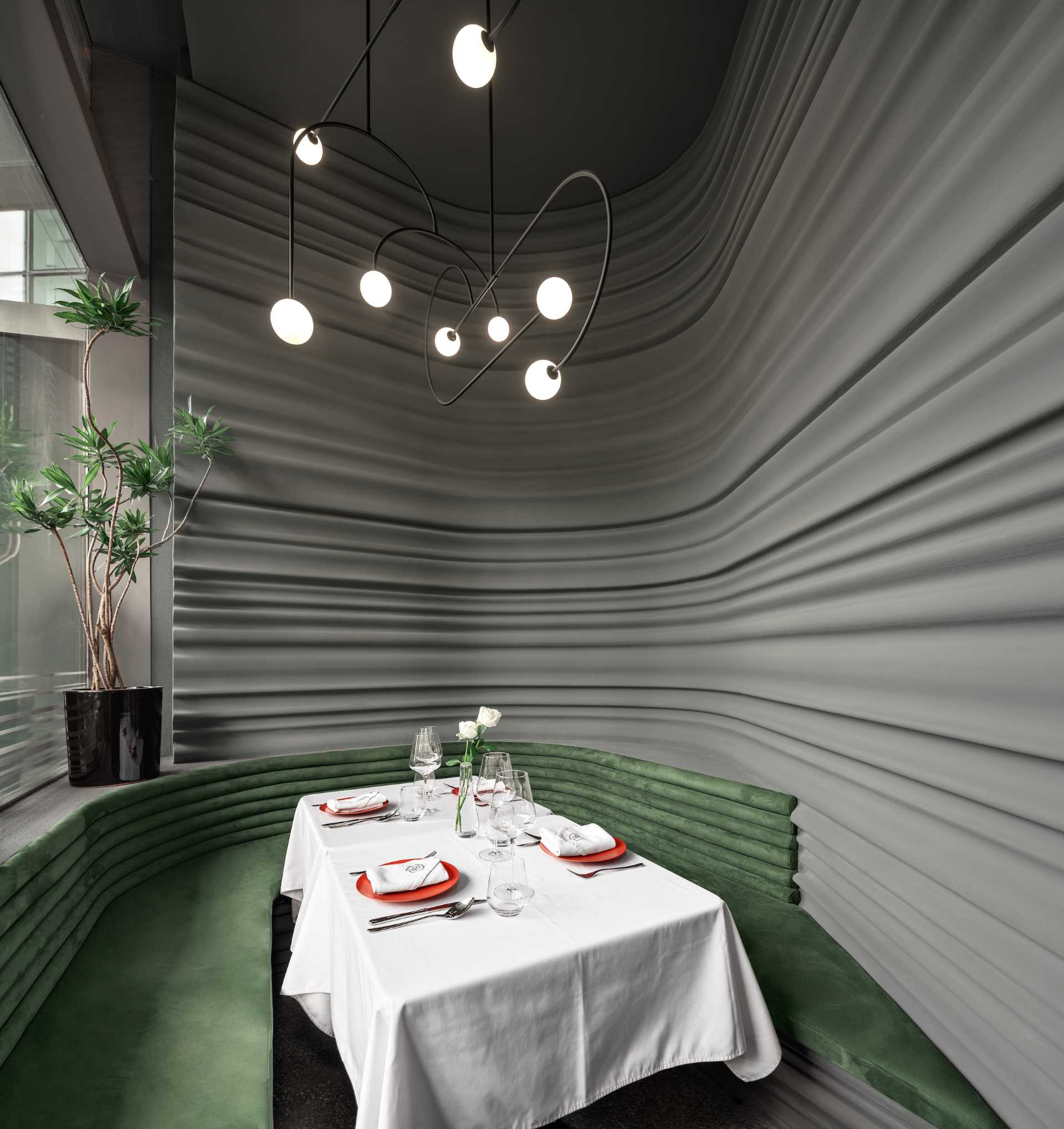 The gray sculptural lines lines of this modern restaurant, extend into the private room, which also includes matching curved banquette seating.