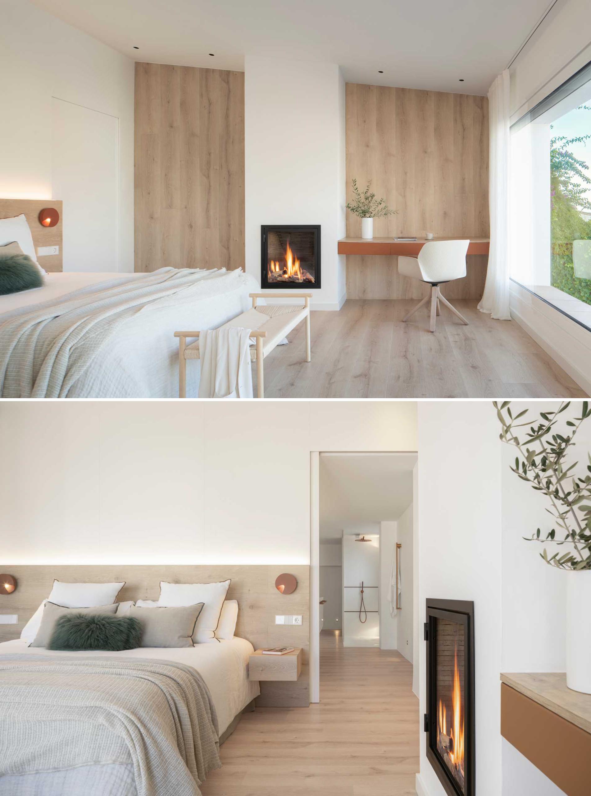 A modern bedroom with oak floors that wrap up onto the wall on either side of the fireplace.