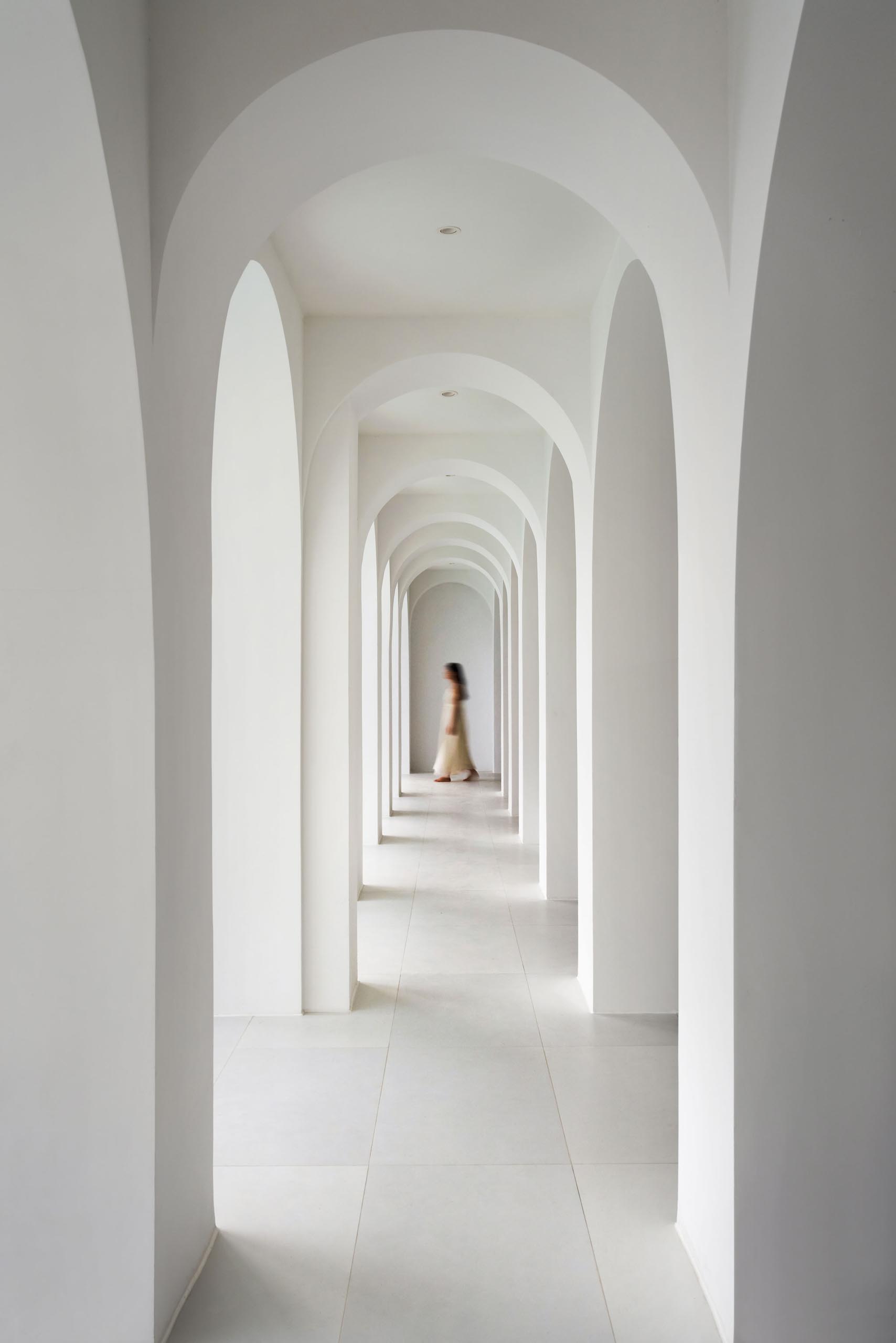 A modern walk walkway in a hotel with arches.