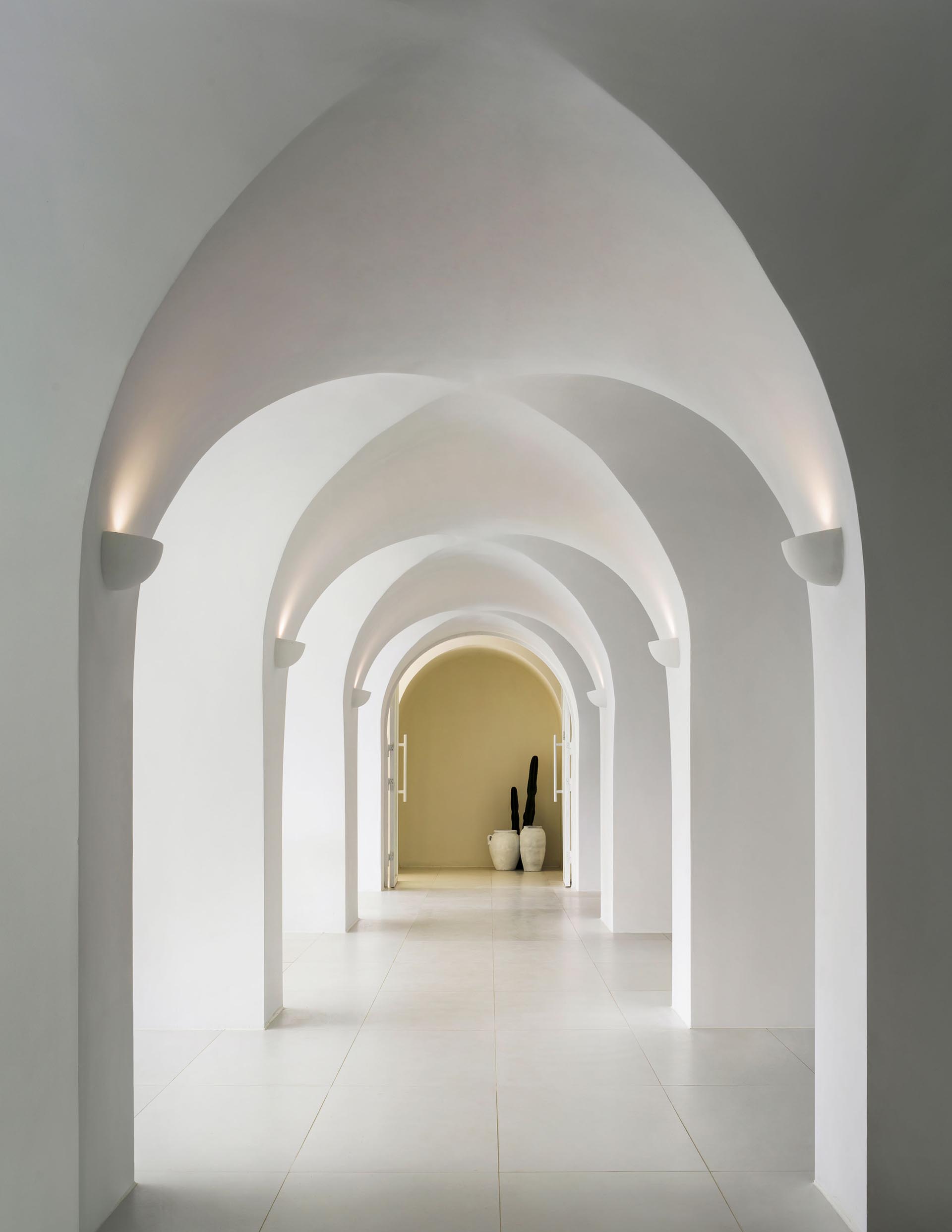 A minimalist hotel hallway that showcases arches.