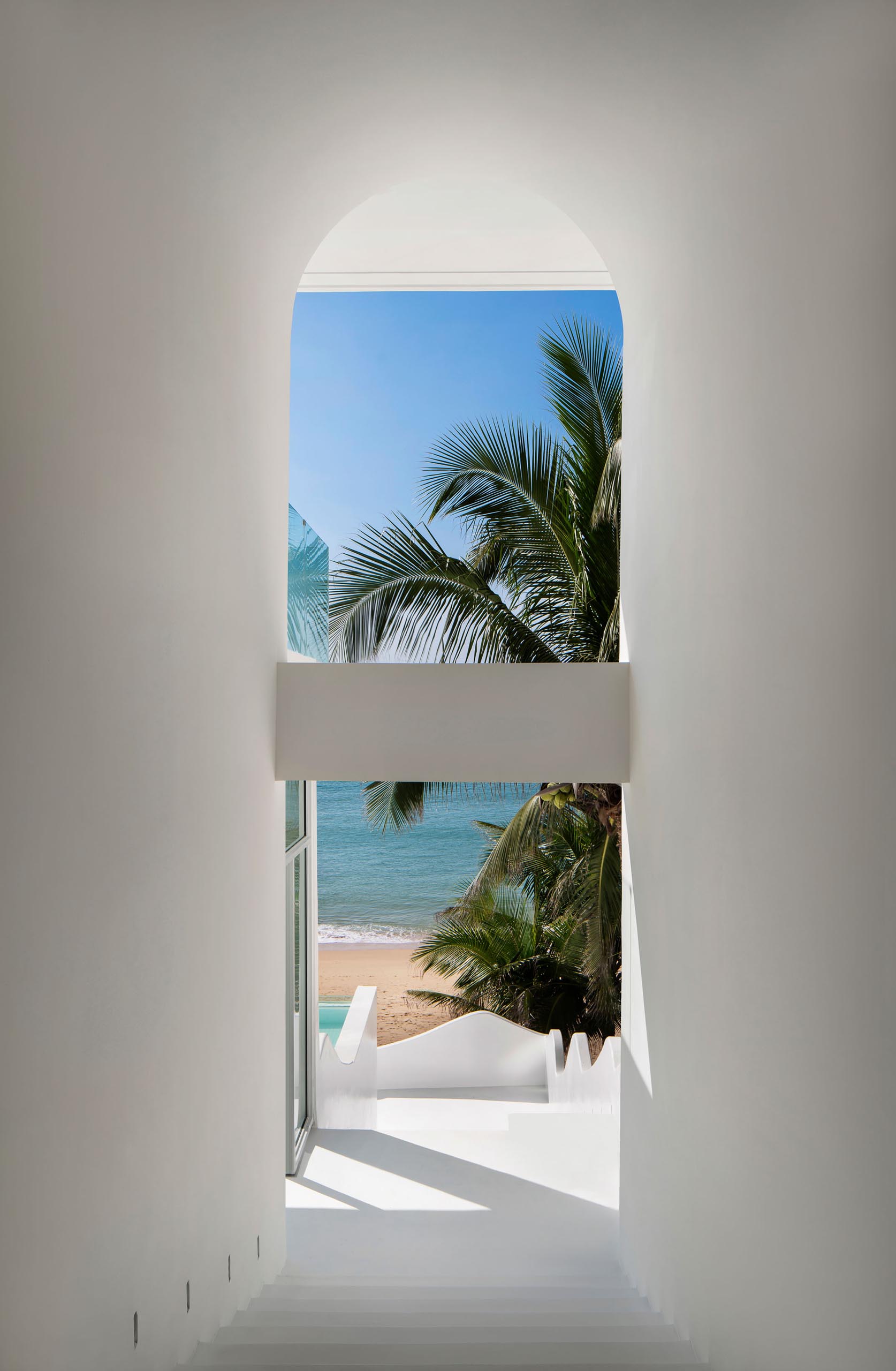 A modern hotel hallway with views of the beach.