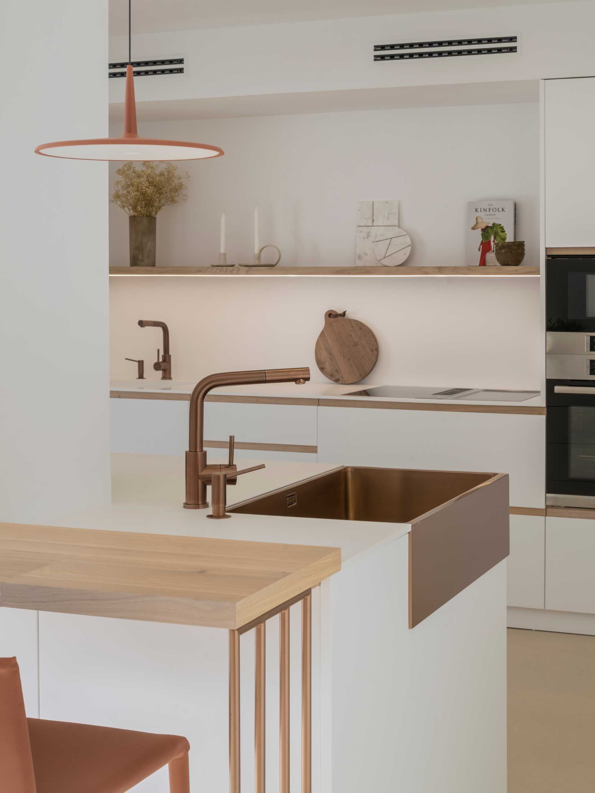 A modern kitchen with a white and copper color palette.