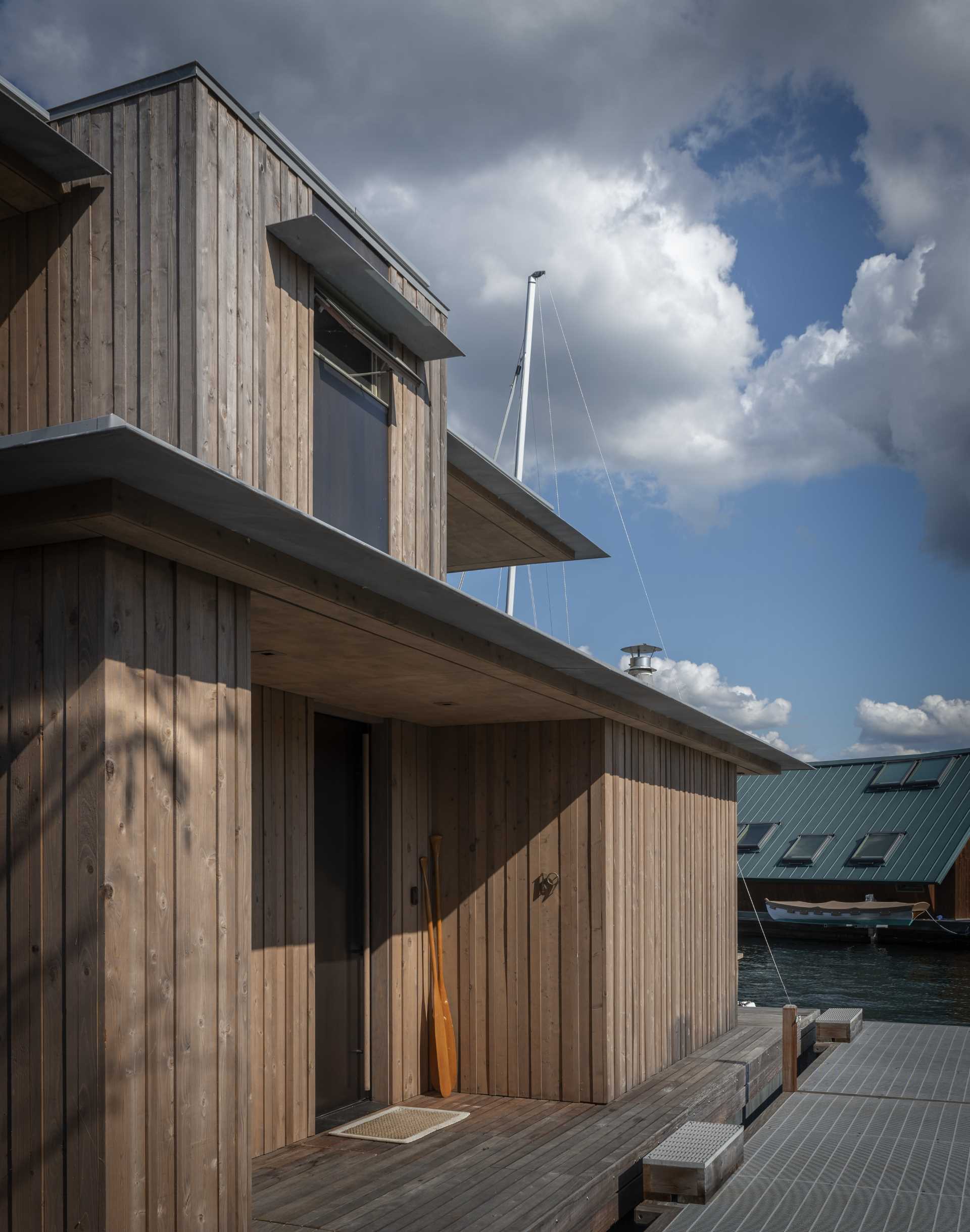 A modern floathome with lightly stained knotty western red cedar exterior siding, which will weather over time with minimal maintenance.
