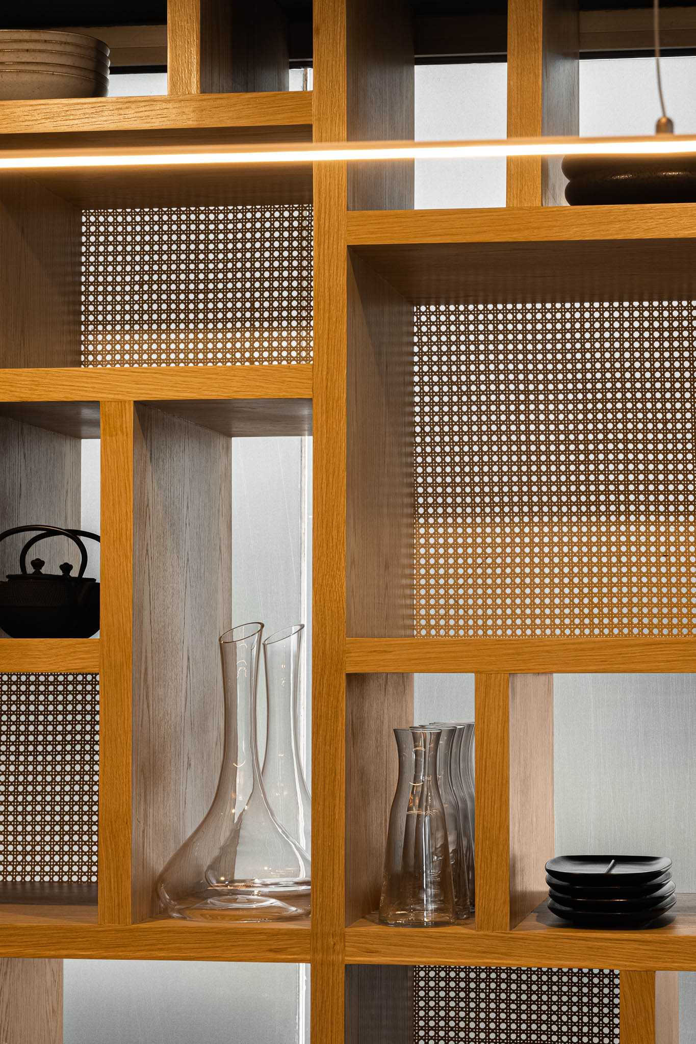 A modern wood shelving unit with straw panels.