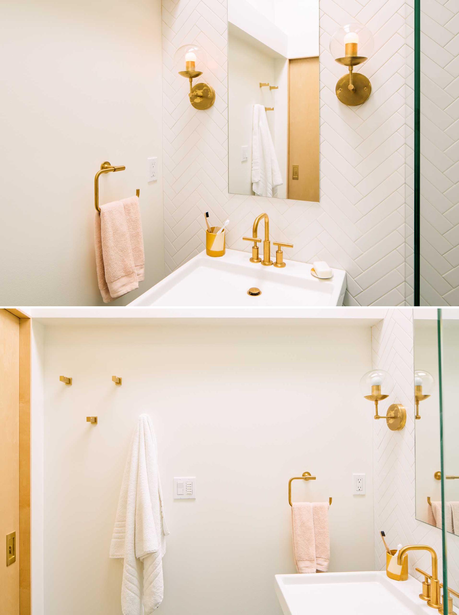 A modern bathroom with a small vanity area, a tiled wall in a herringbone pattern, a walk-in shower, and a skylight.