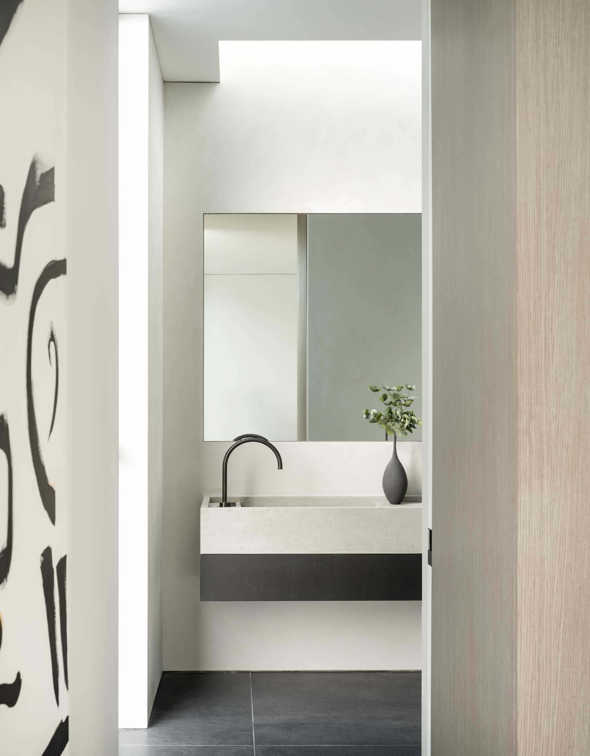 A modern bathroom with black tiled floor and a floating vanity.