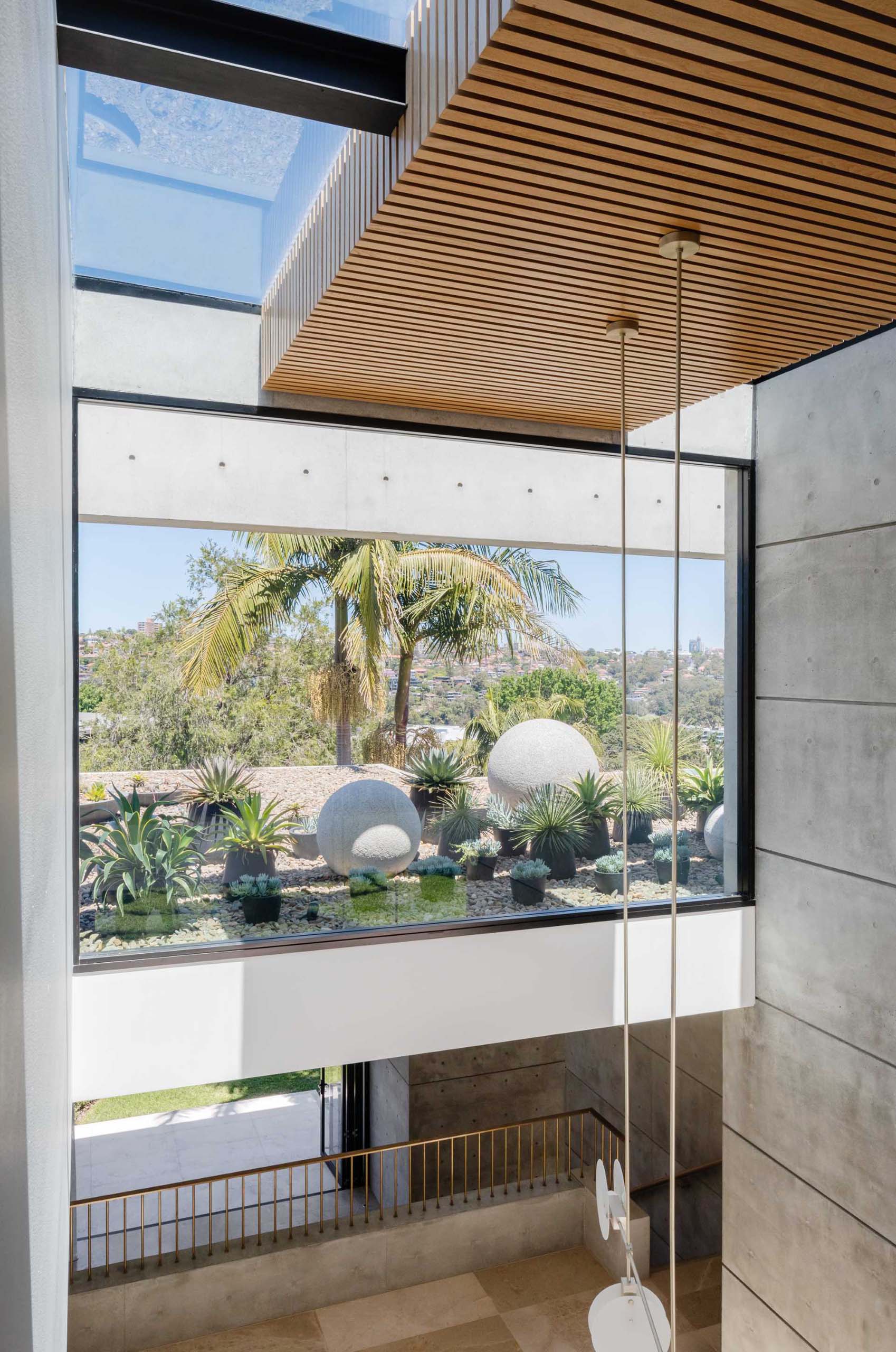 A large picture window, as well as skylights, ensure ample natural light filters through to the interior of this modern home, and allows for views of the succulent filled planters positioned on the roof of the lower level.