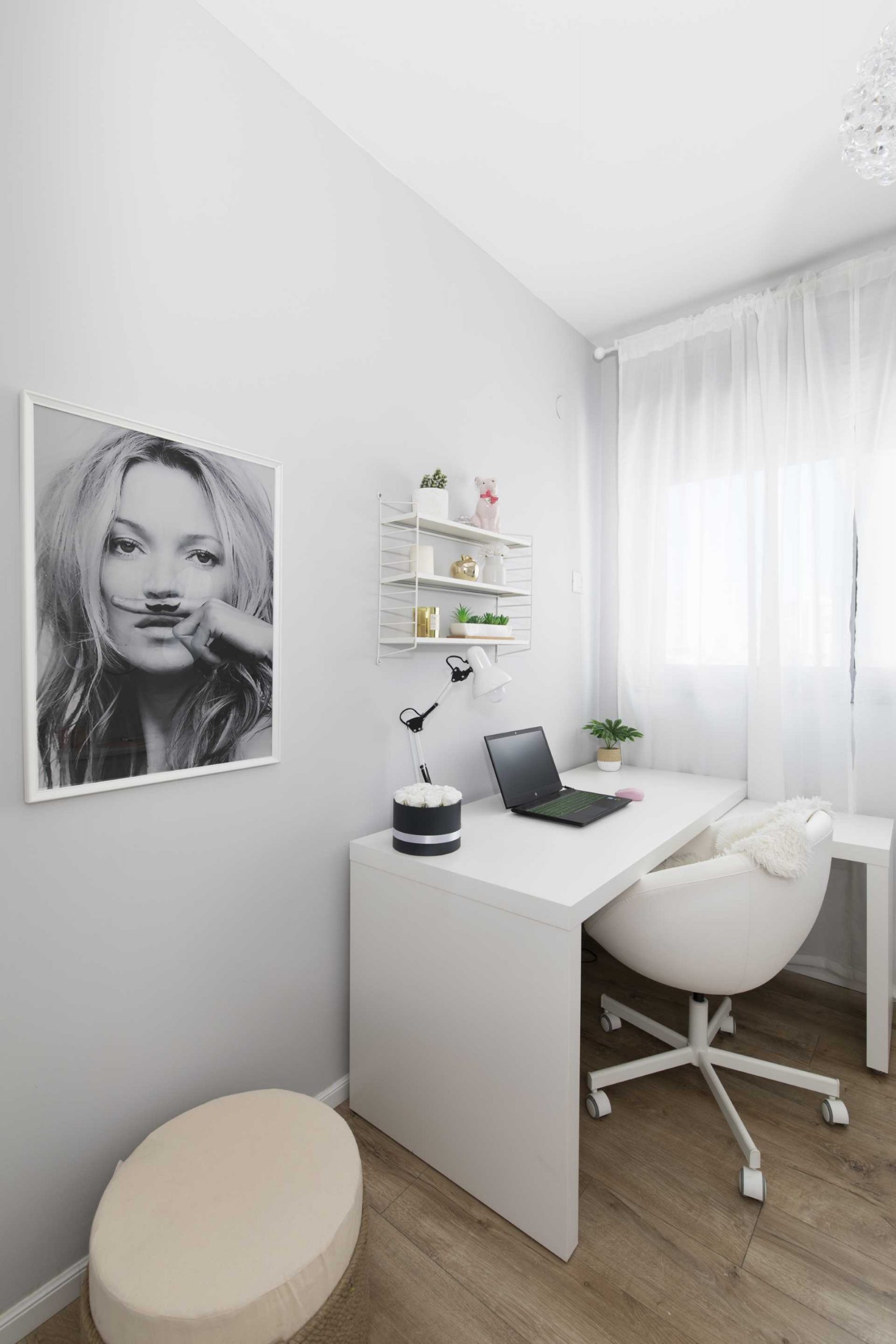 In this modern home office, the walls have been painted with a very light gray color, while a crystal ceiling lamp and sheer white curtains create a calm atmosphere.