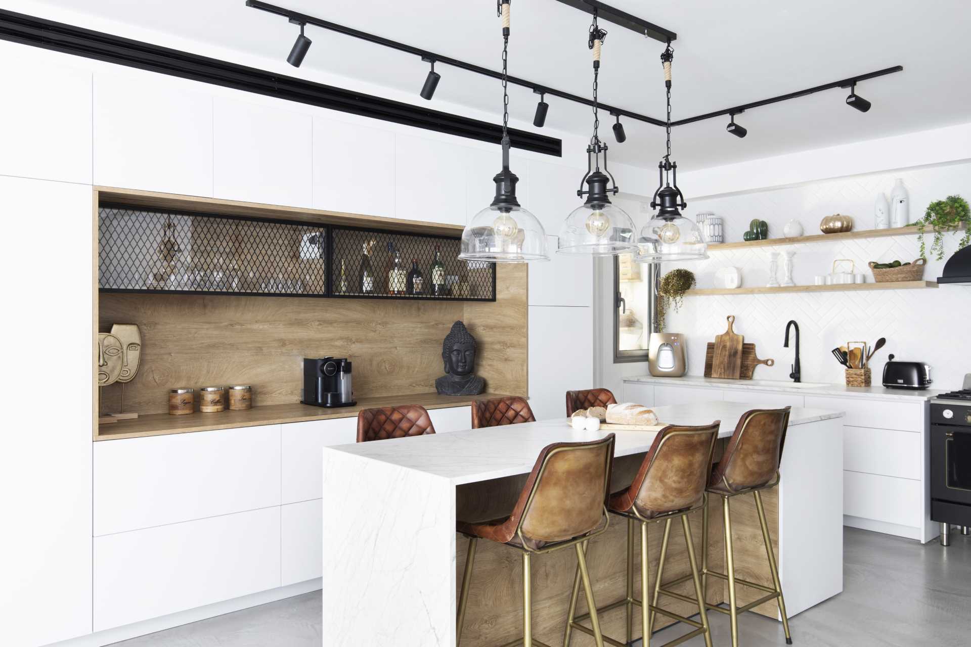A modern white kitchen with eat-in island and wood accents.