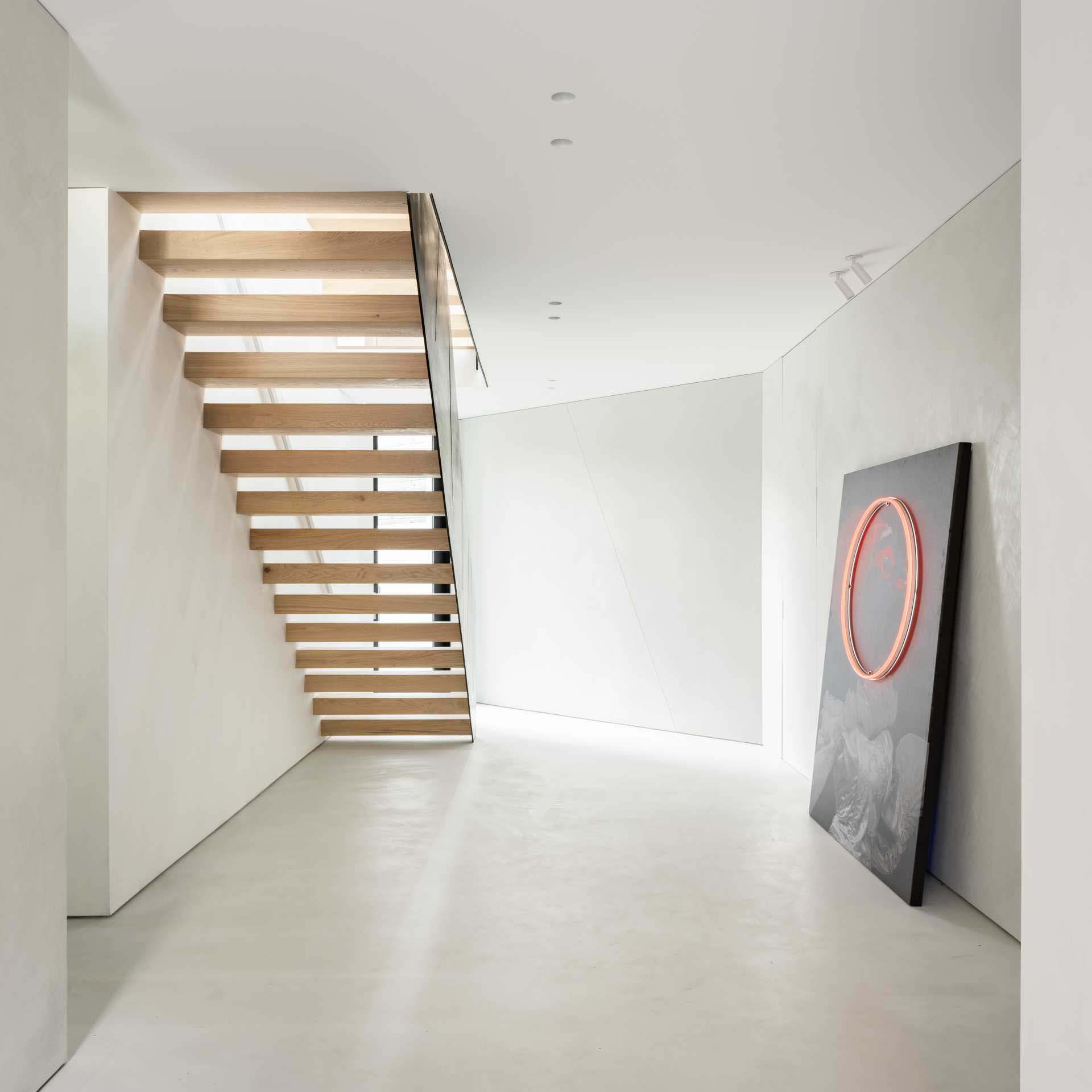 The architectural steel plate staircase with wood treads bounces light throughout the three levels of living space in this modern home.