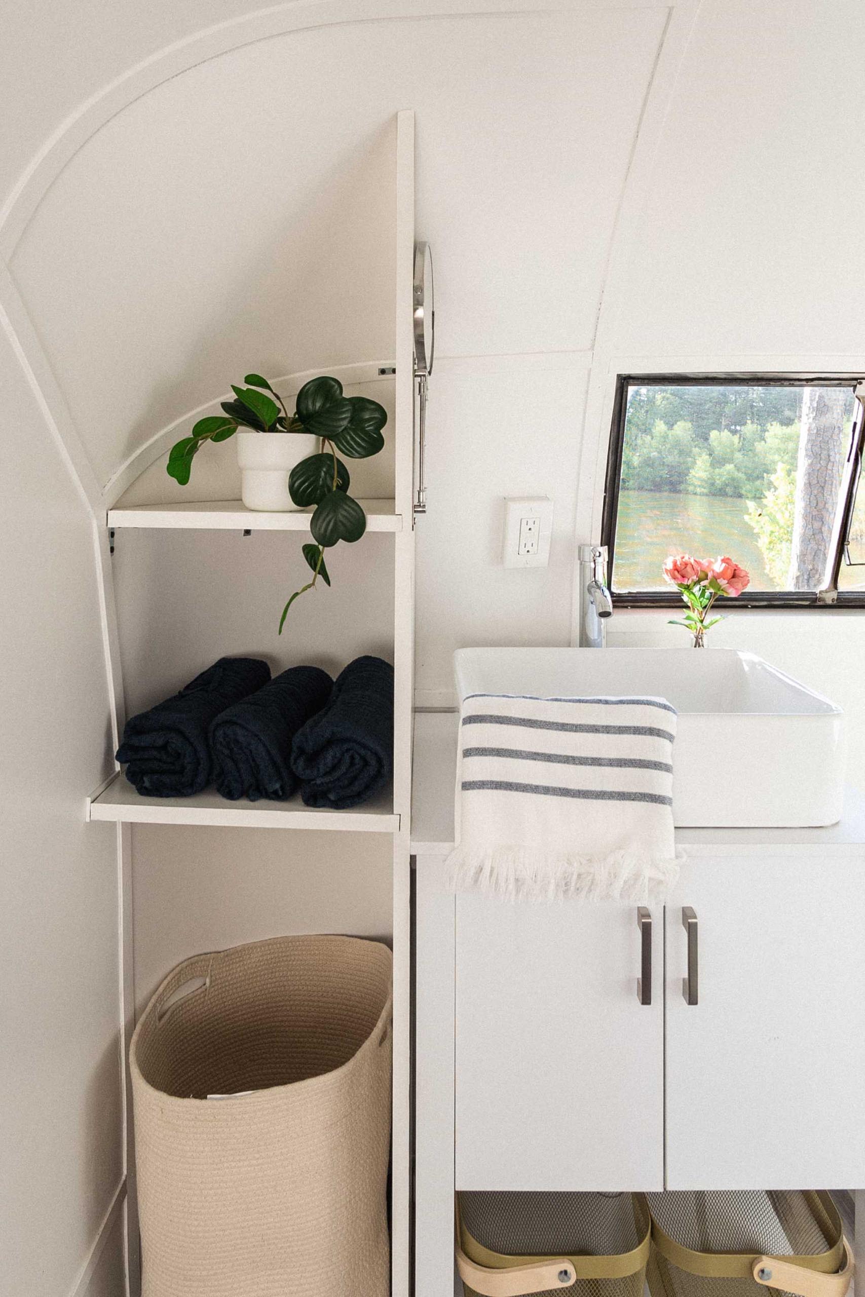 This renovated vintage travel trailer includes a spa-inspired bathroom, with built-in shelving and a vanity.