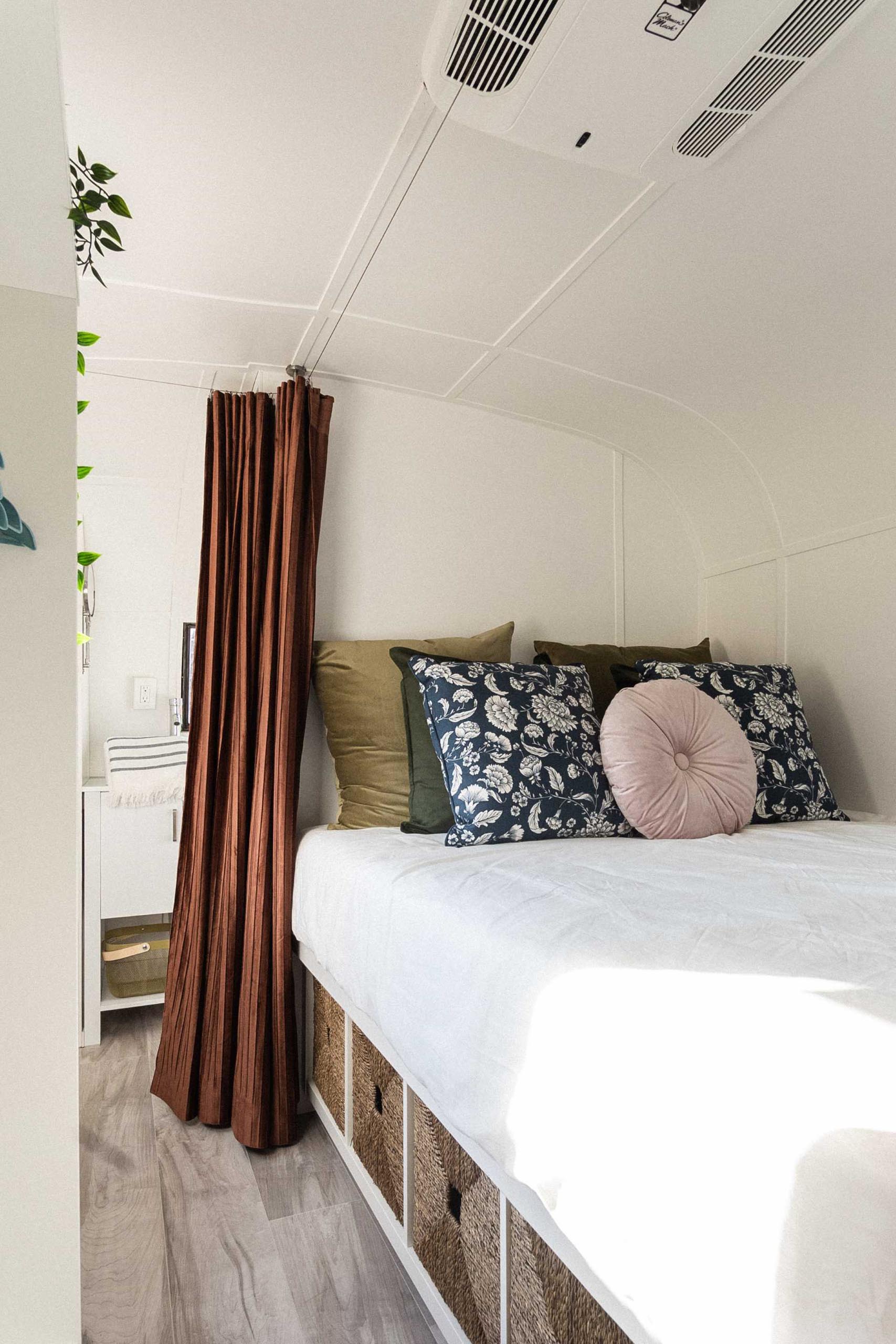 The modern bedroom of a remodeled vintage travel trailer.