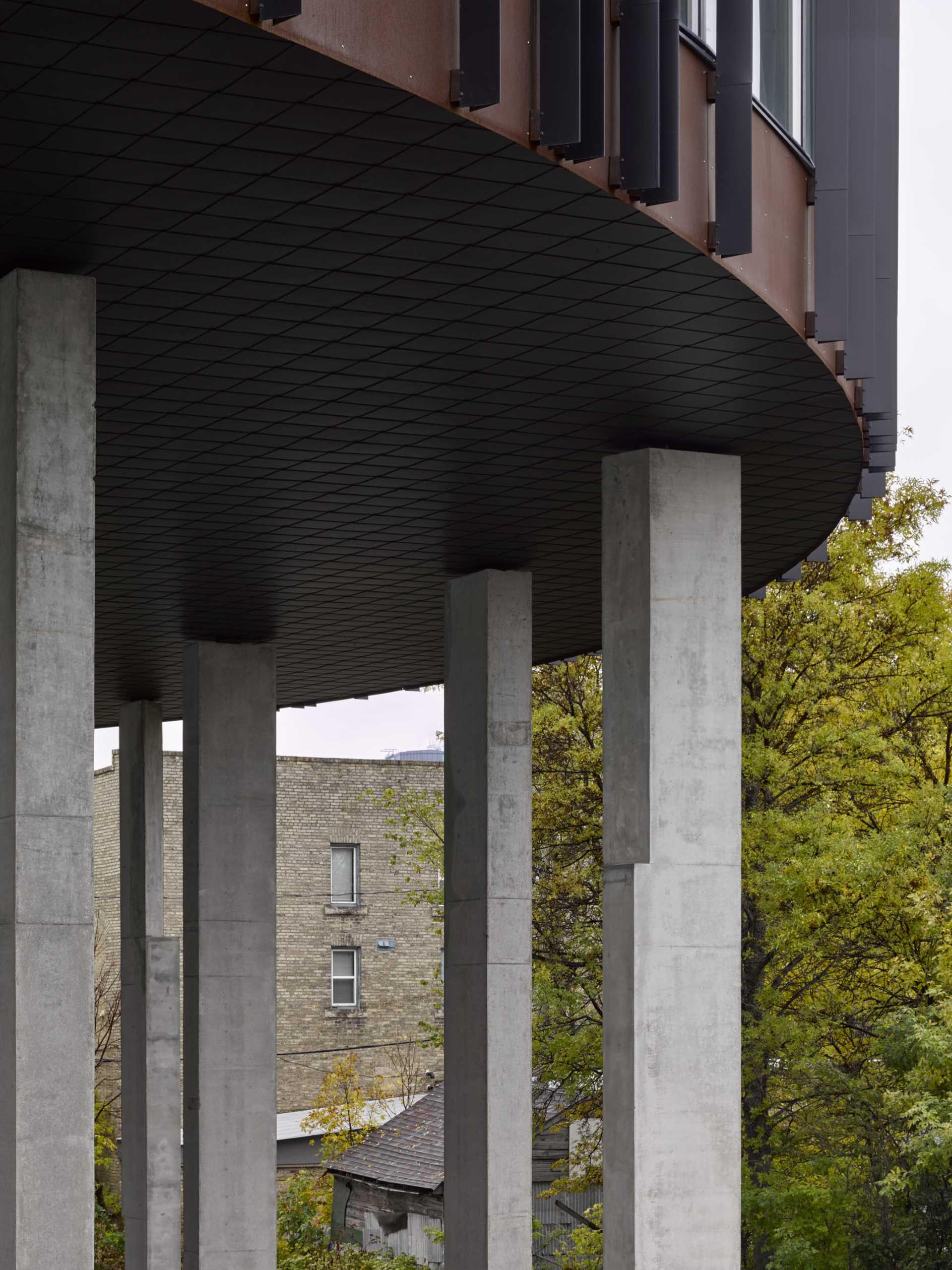 20 concrete columns support a round apartment building.