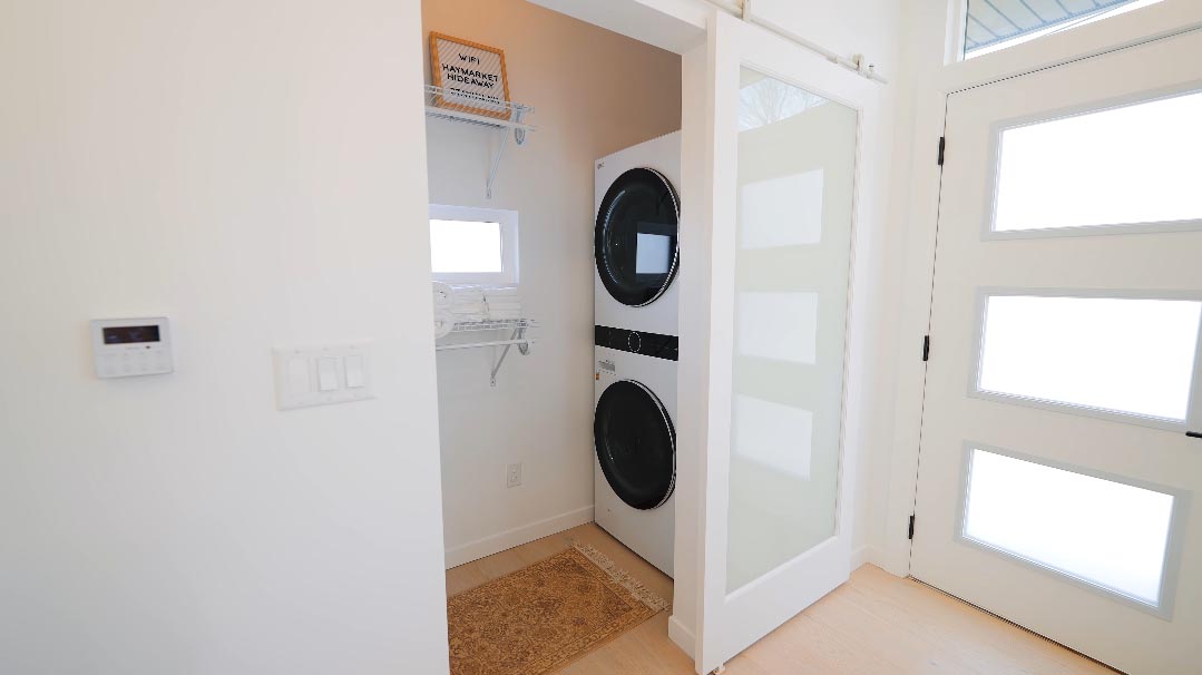 A tiny house with a laundry room includes both a washer and dryer.
