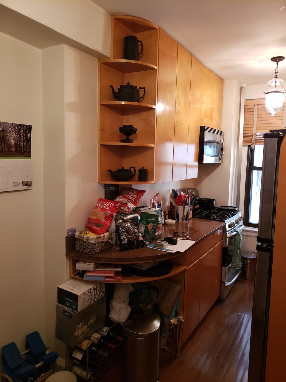 Before Photo - the remodel of a dated galley kitchen with curved corner shelving.
