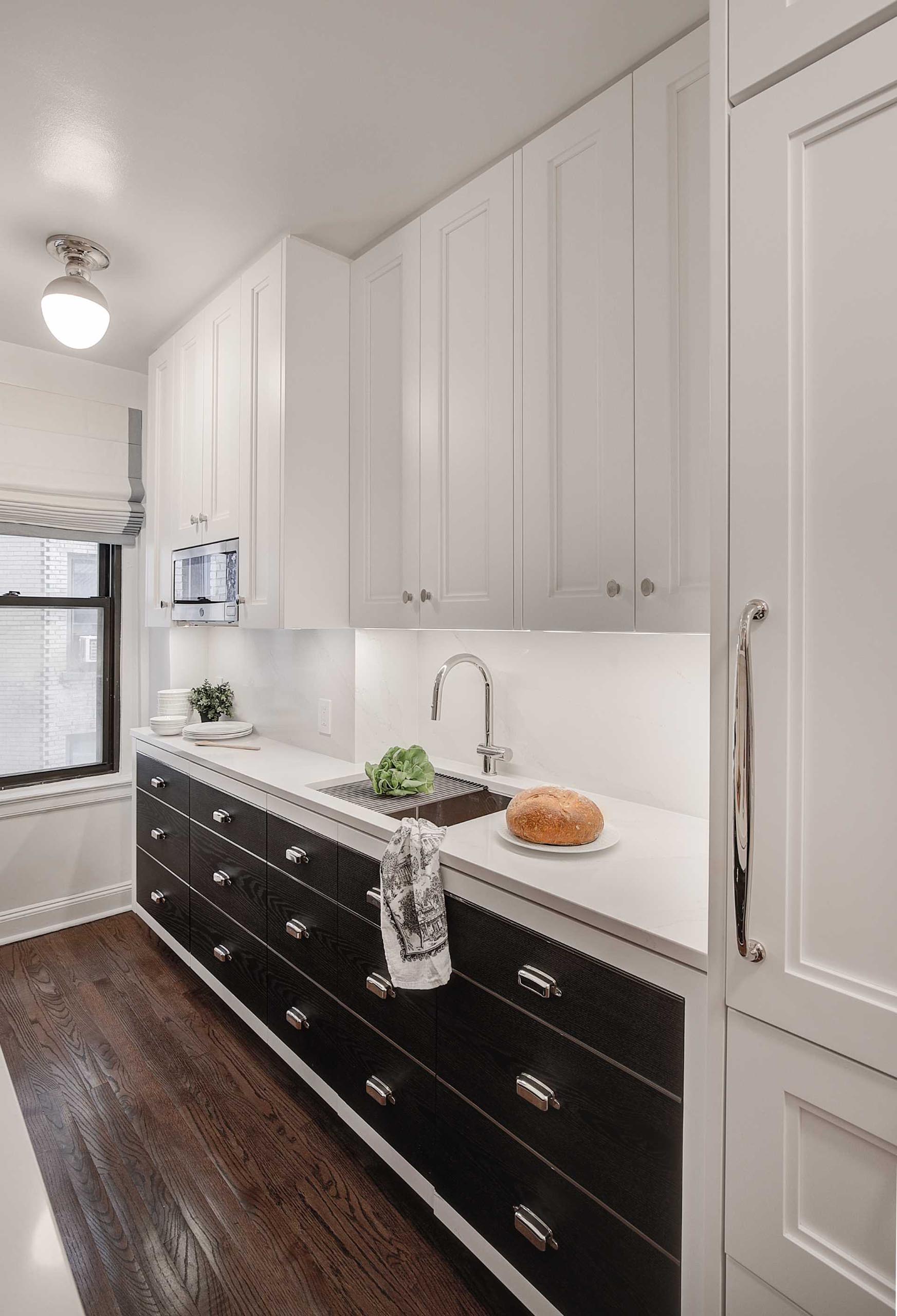 In this contemporary kitchen, polished nickel inlay accents create the look of drawers throughout, even on cabinet doors.