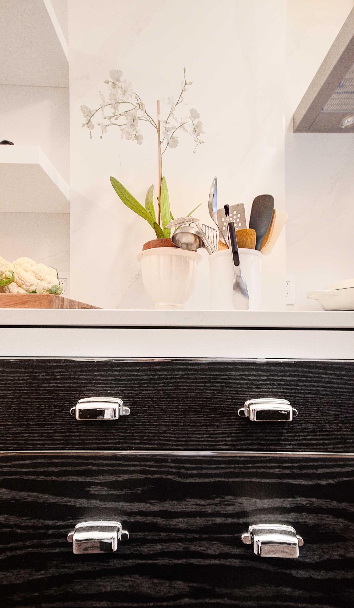 Polished nickel inlay accents create the look of drawers throughout this kitchen, even on cabinet doors.