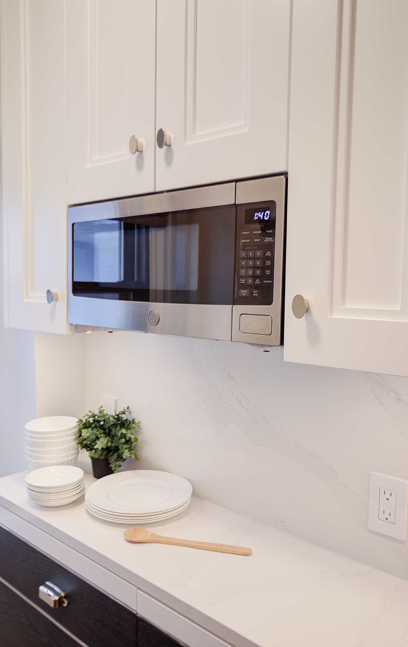 A contemporary kitchen with a built-in microwave that sits flush with the surrounding cabinets.