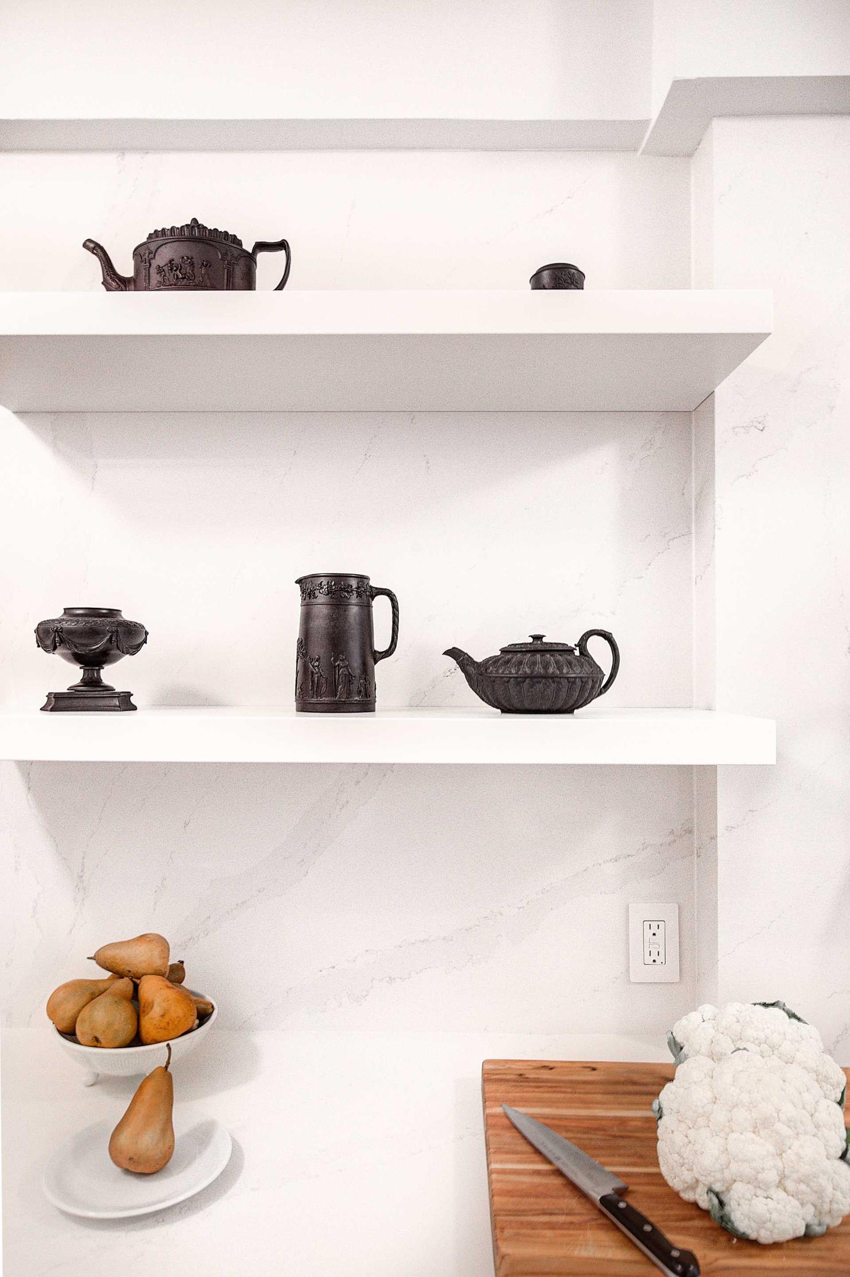 A remodeled kitchen with a pair of floating shelves that almost blend into the wall.