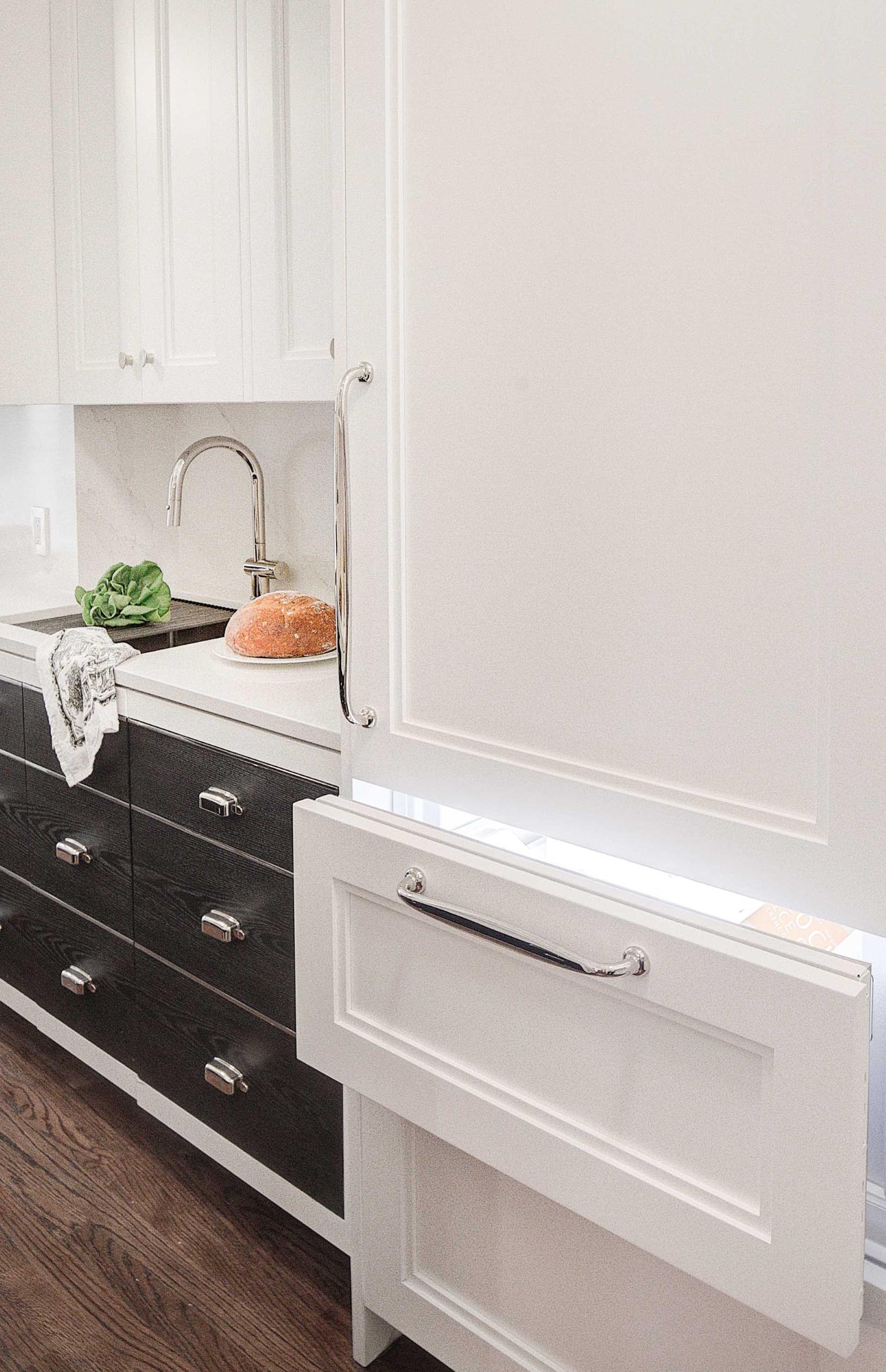 A contemporary kitchen with an integrated fridge, whose front matches the nearby cabinetry.