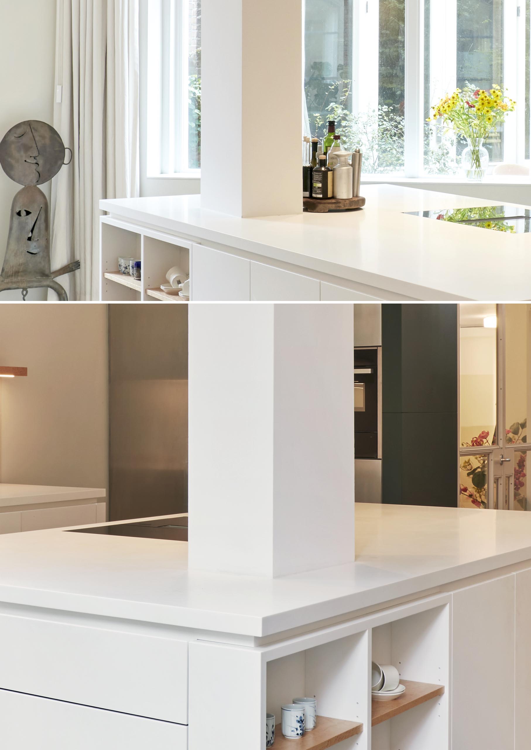 A modern white kitchen with a large island that has the counterop wrap around a tall column.