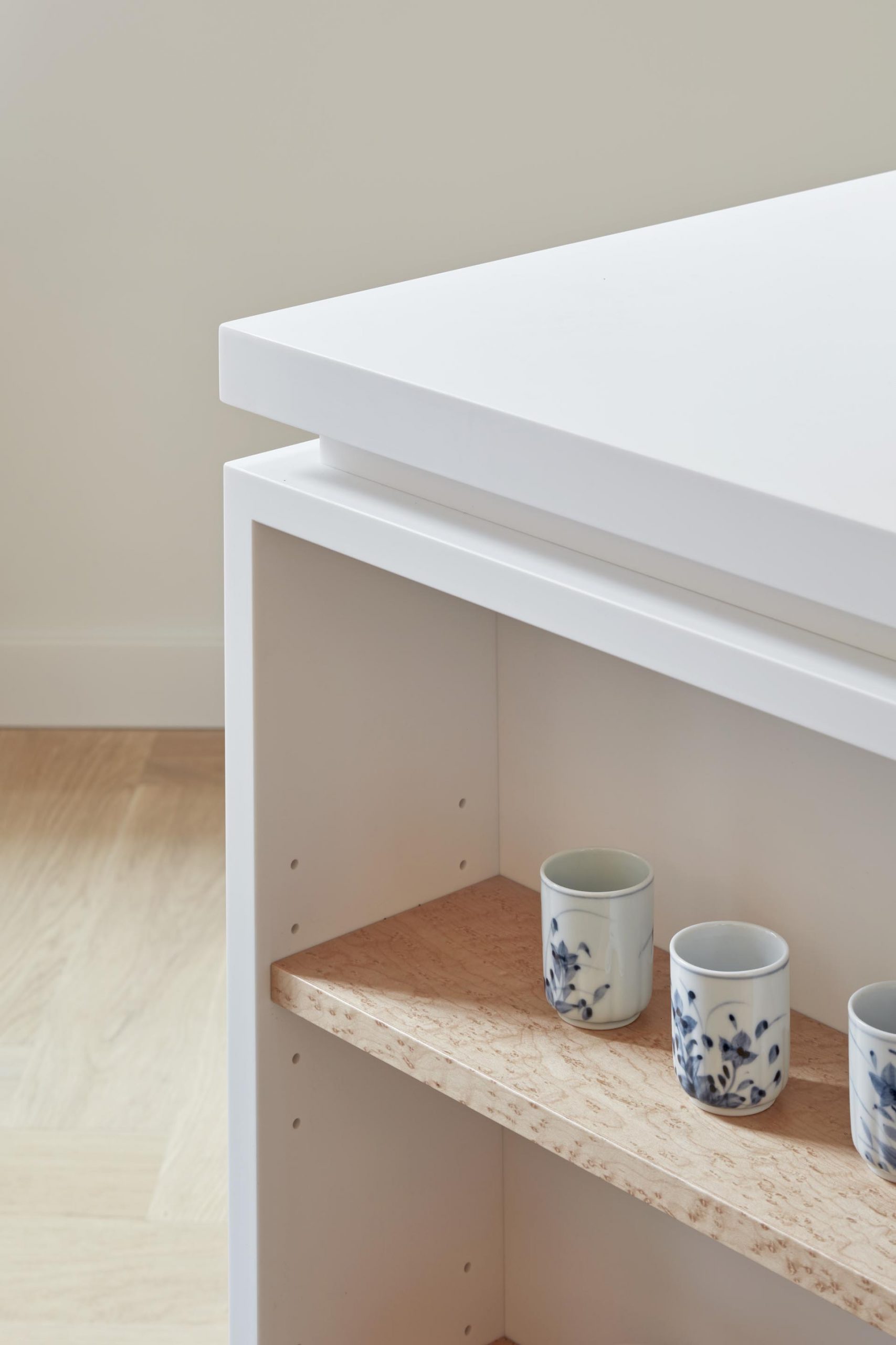 A modern white island with open wood shelving.