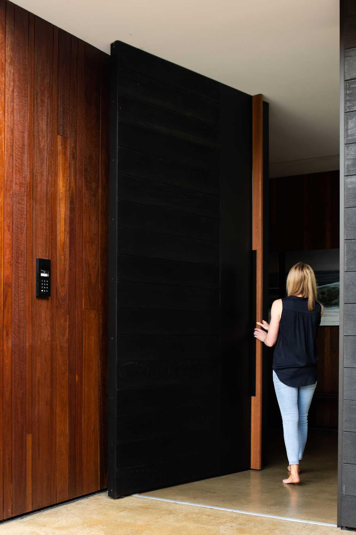 An oversized black pivoting front door.