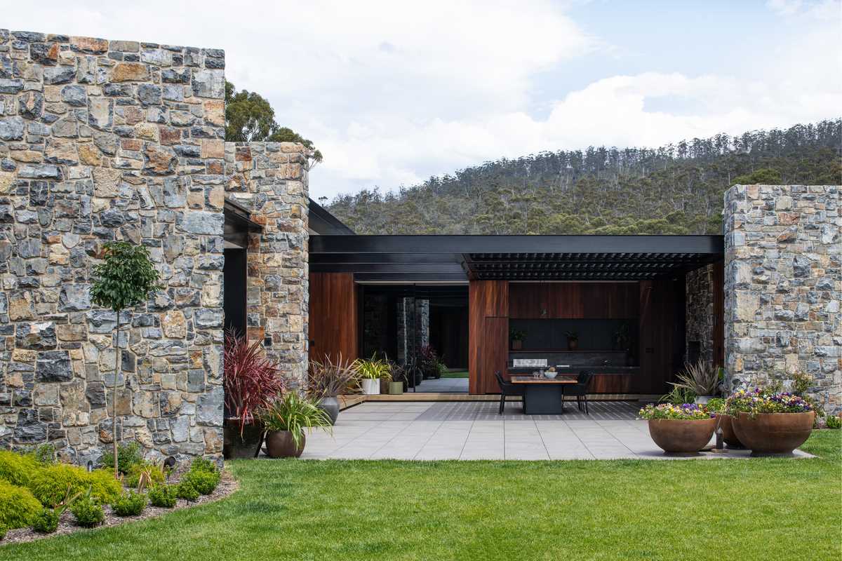 A partially covered courtyard includes a bbq area, fireplace, and a space for outdoor dining.