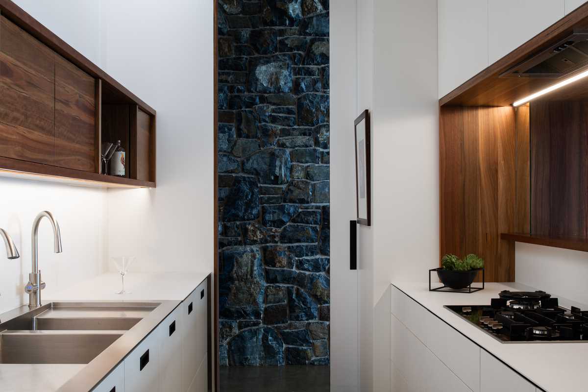 A modern butlers pantry with minimalist white cabinets.