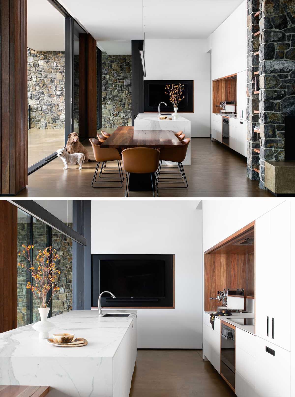 A modern kitchen with minimalist white cabinets that line the walls, while the island has been designed with an eat-in area.