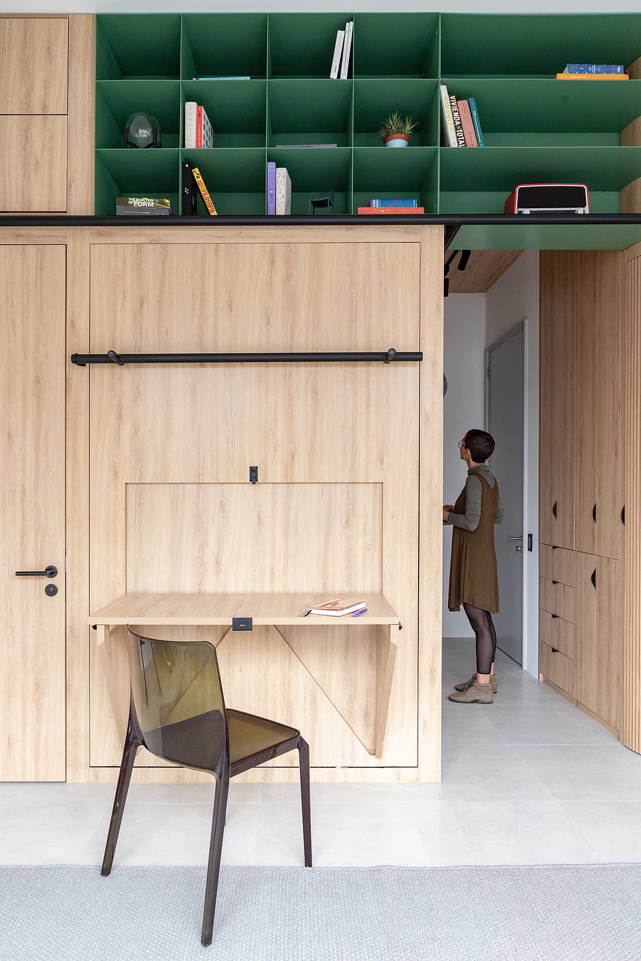 A small studio apartment with a built-in desk that can be dropped down.