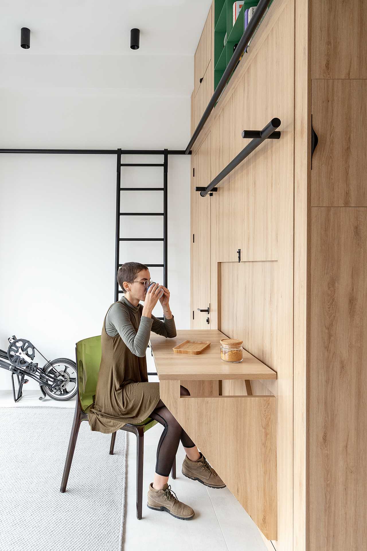 A small studio apartment with a built-in desk that can be folded down or locked in place when not in use.