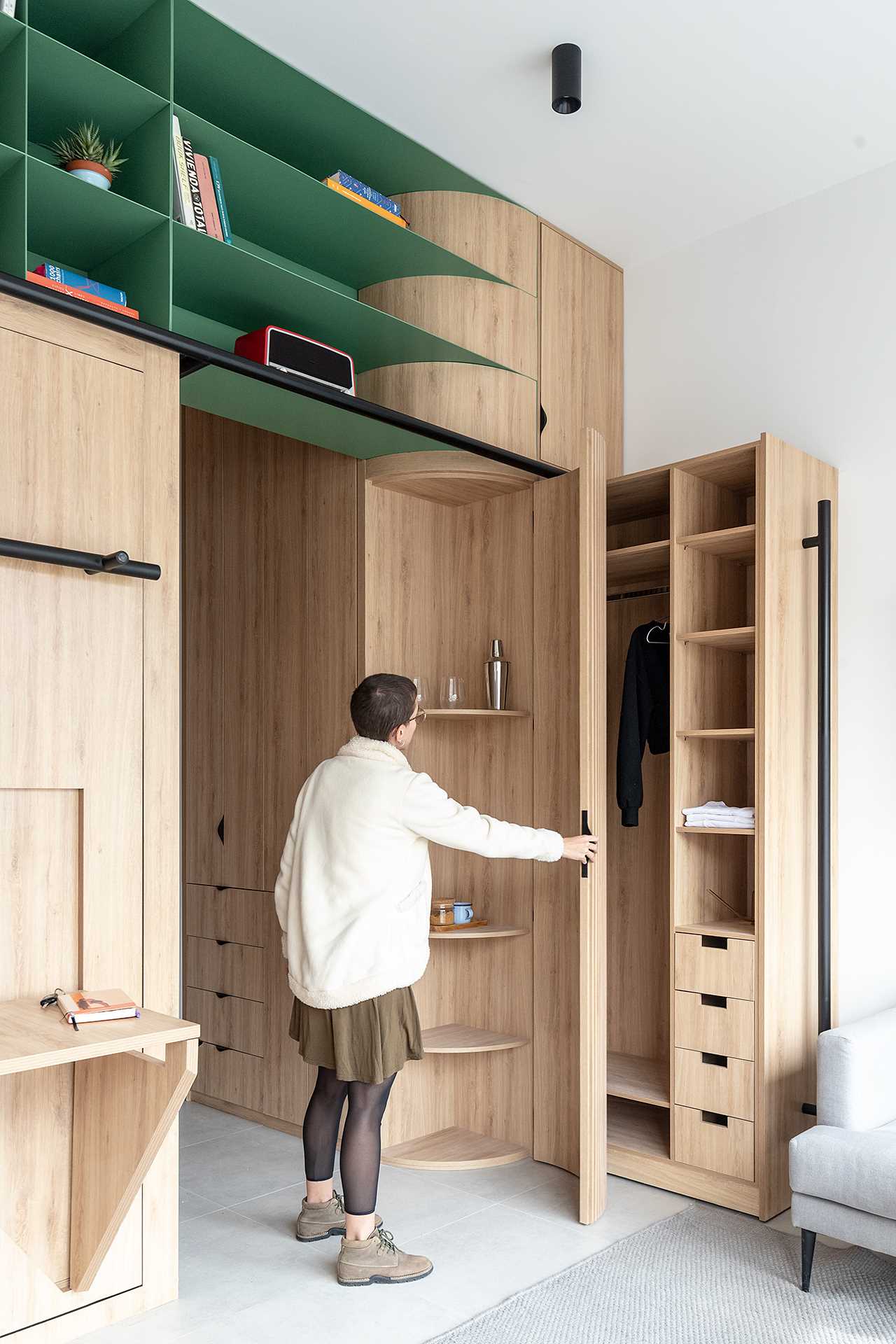 The corner has been softened with a curved cabinet that opens to shelving.