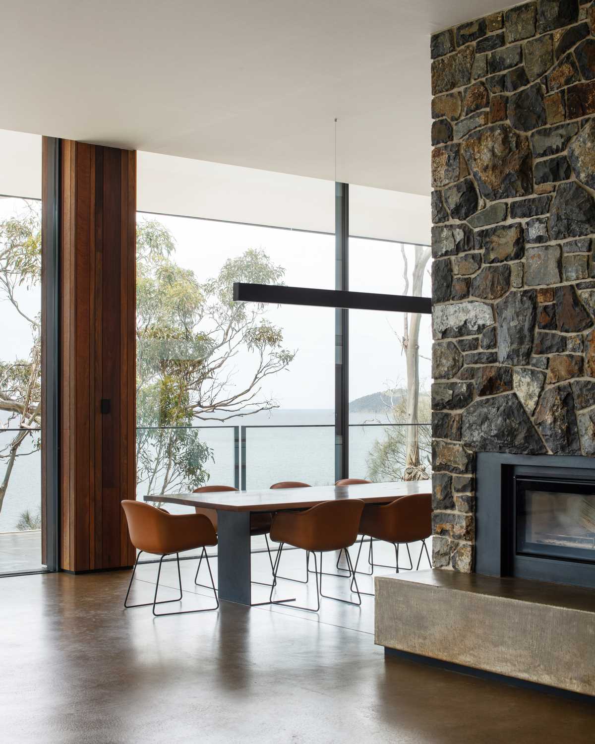 A fireplace embedded into the stone wall can be enjoyed in the dining area that separates the living room from the kitchen.