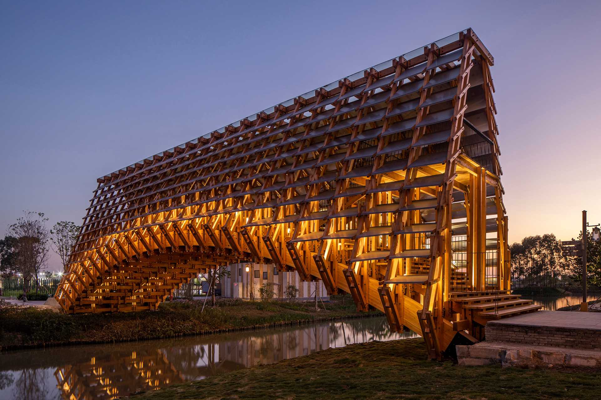 A new arched pedestrian bridge that's been built using pine wood, concrete, aluminum plate, and glass.