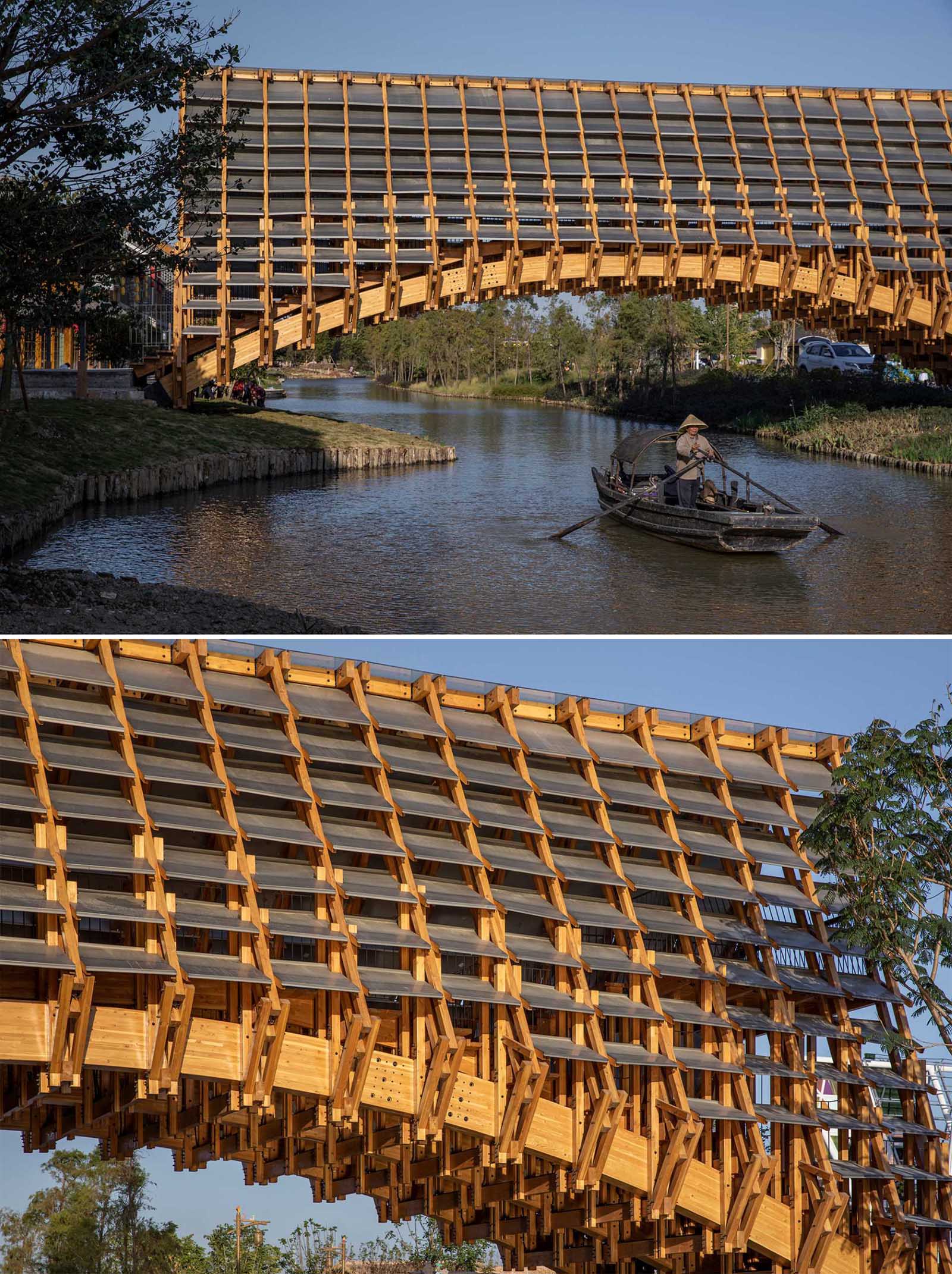 An arched pedestrian bridge made from wood allows traditional fishing boast to pass underneath.