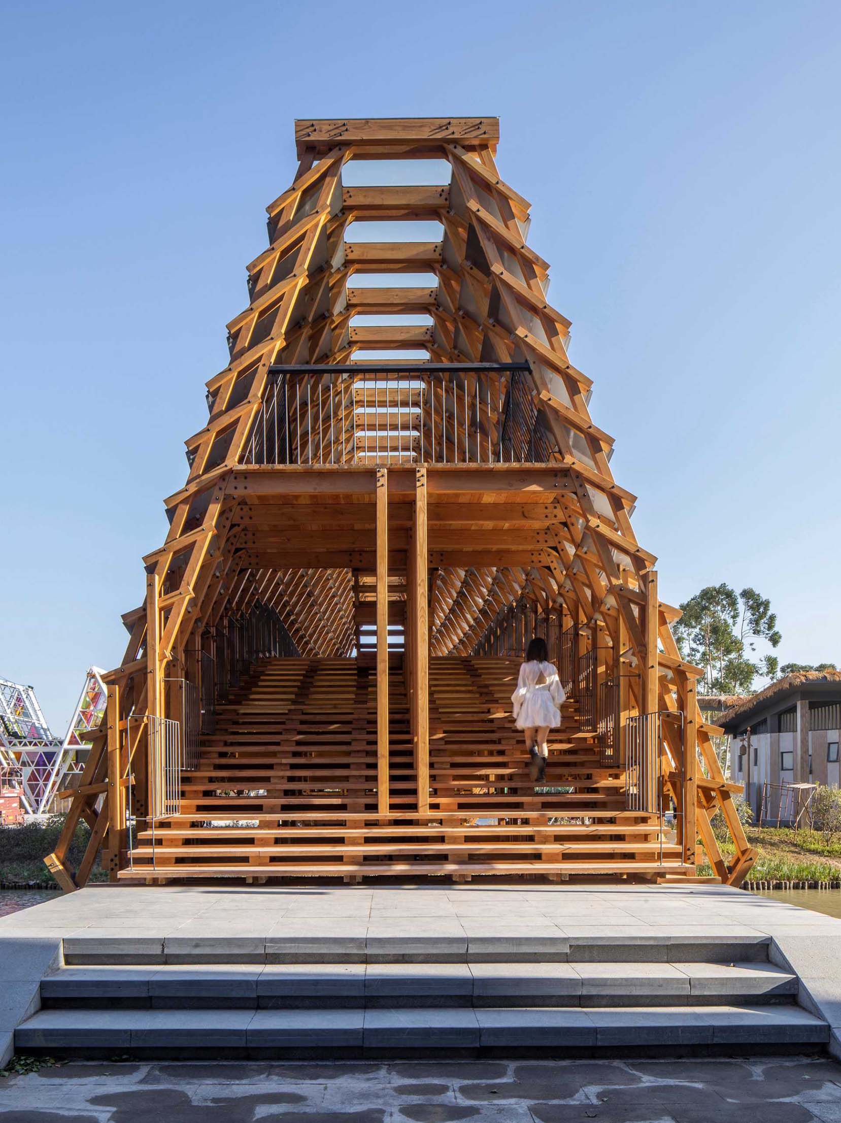 A wood pedestrian bridge designed with 3 large curved beams as main structural components.