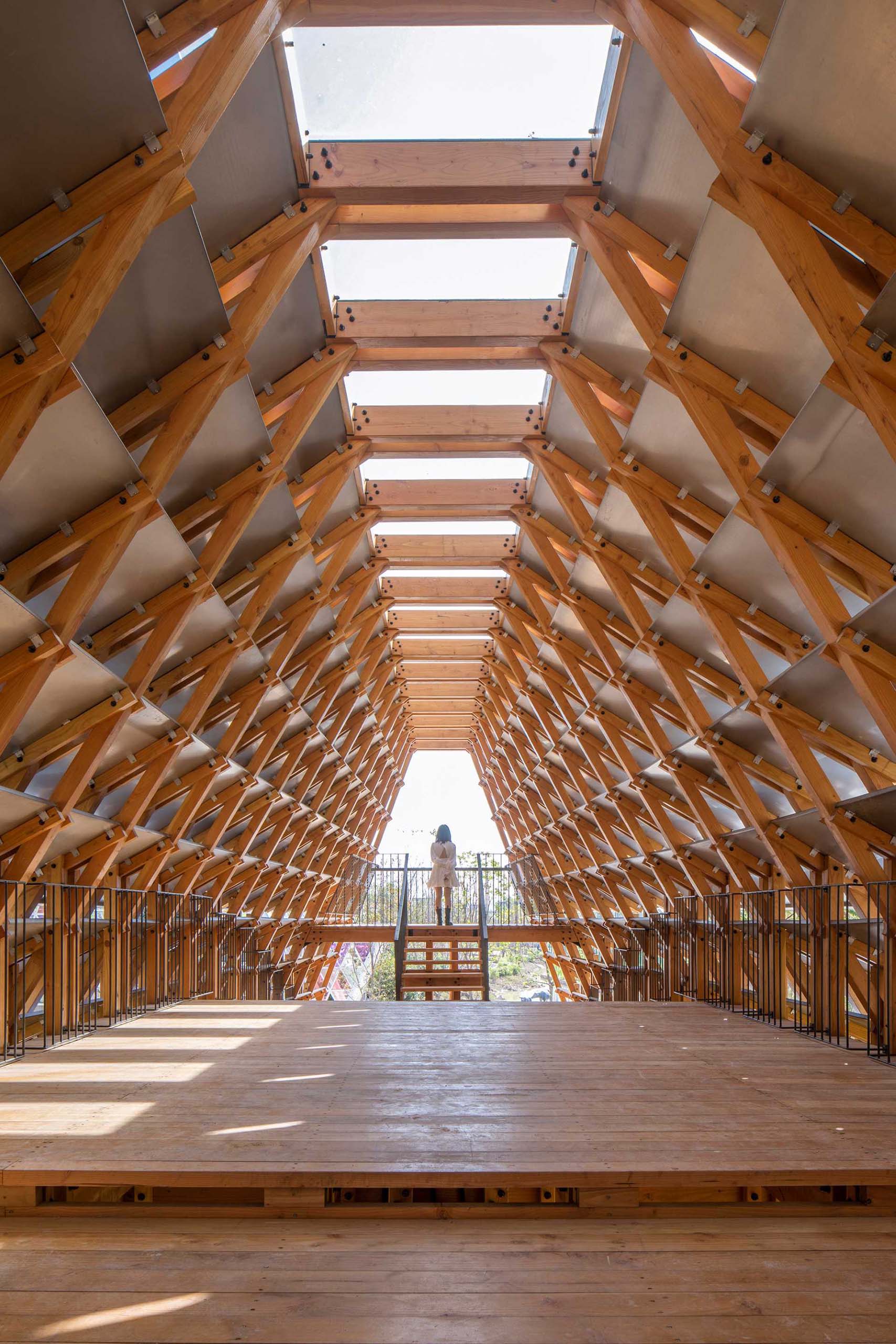 A covered pedestrian bridge made from wood and steel plates.