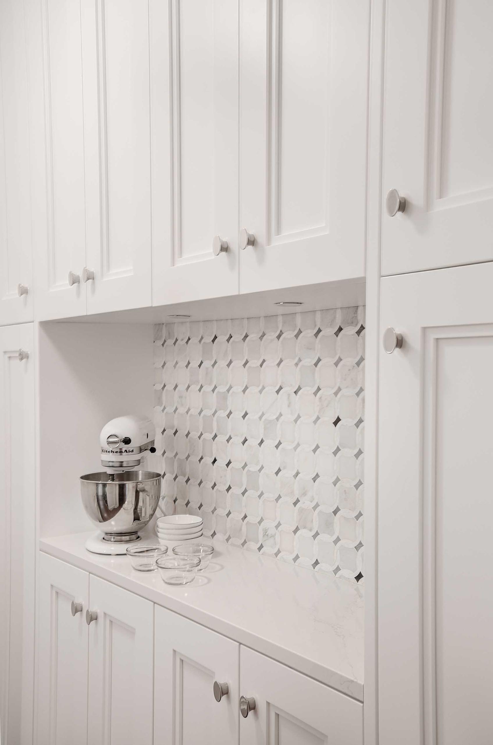 In this kitchen, a tile backsplash in a decorative pattern creates a focal point.