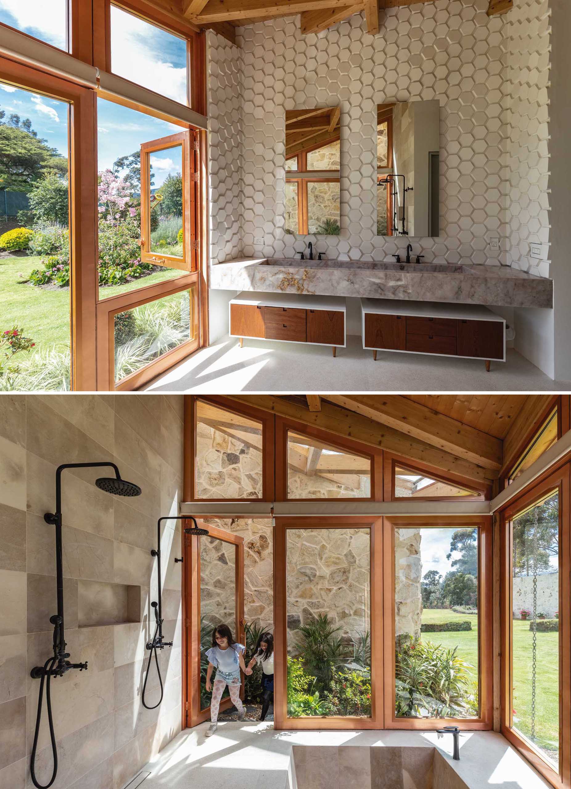 In this modern bathroom, there's an accent wall made from hexagonal tiles that creates texture, a dual shower, and an in-ground bathtub.