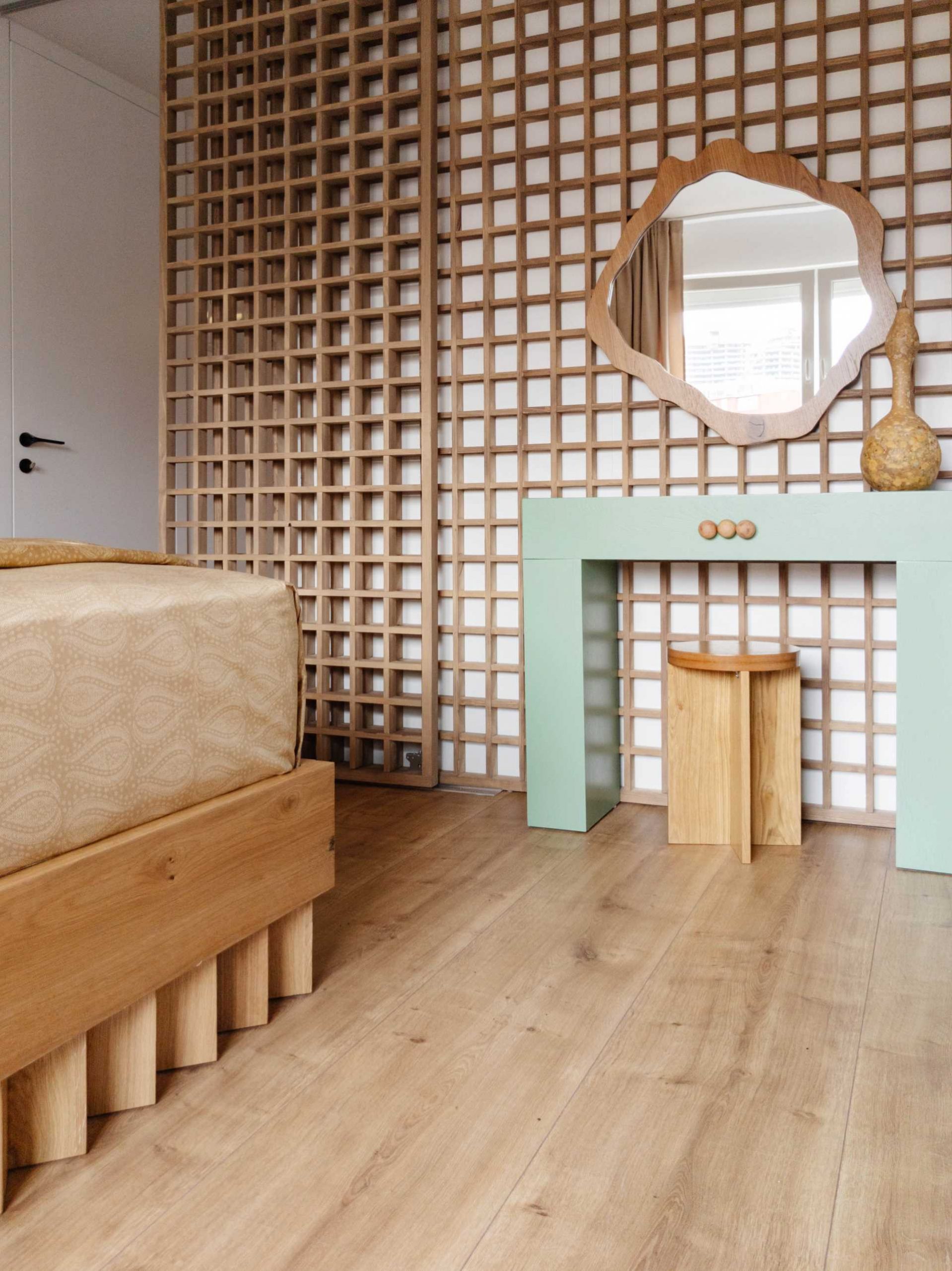 In the bedroom, there's a geometric wood accent that covers the wall, while the a wood bed frame has a unique design for it's base.