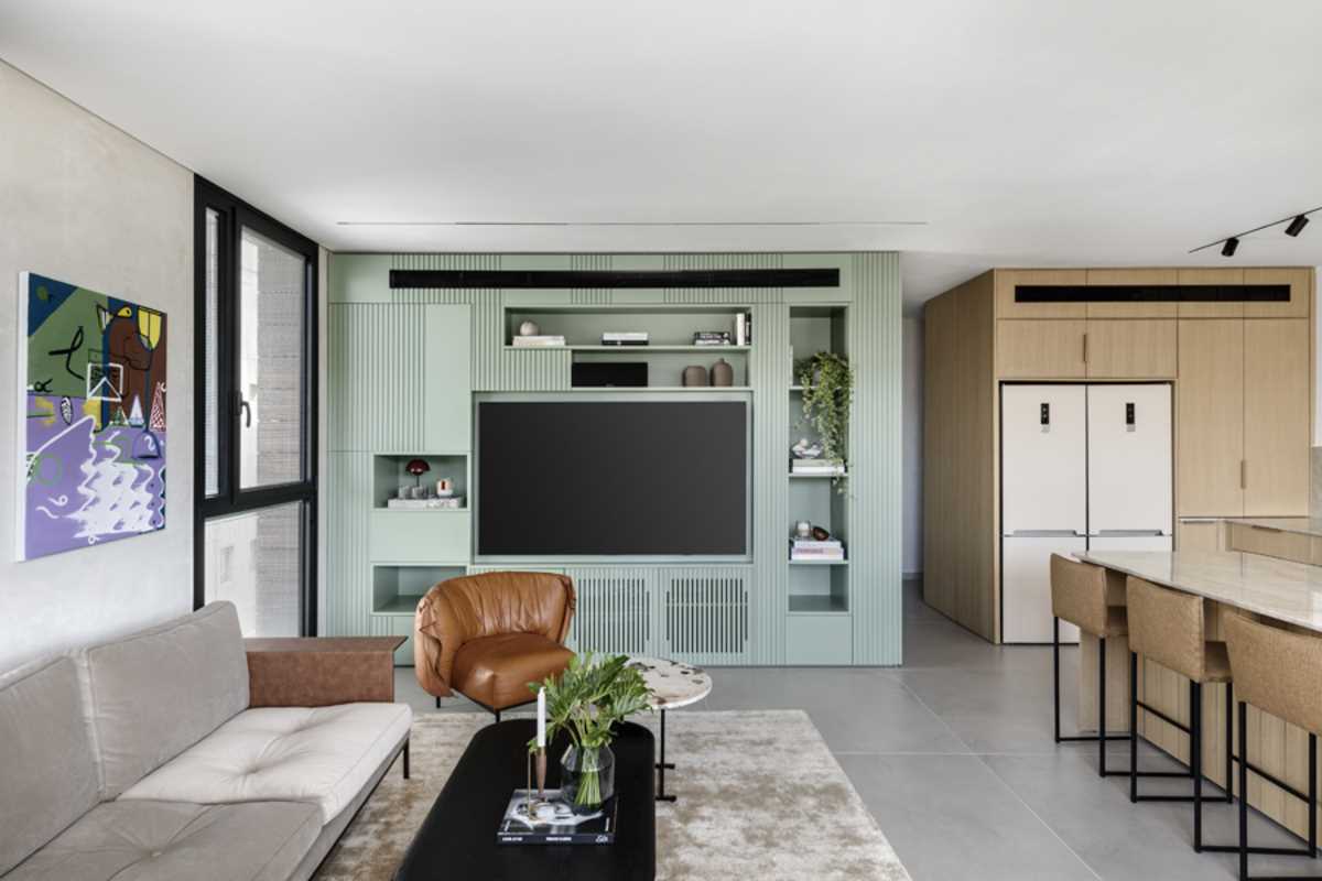 This matte sage green living room accent wall includes hidden storage as well as open shelving.