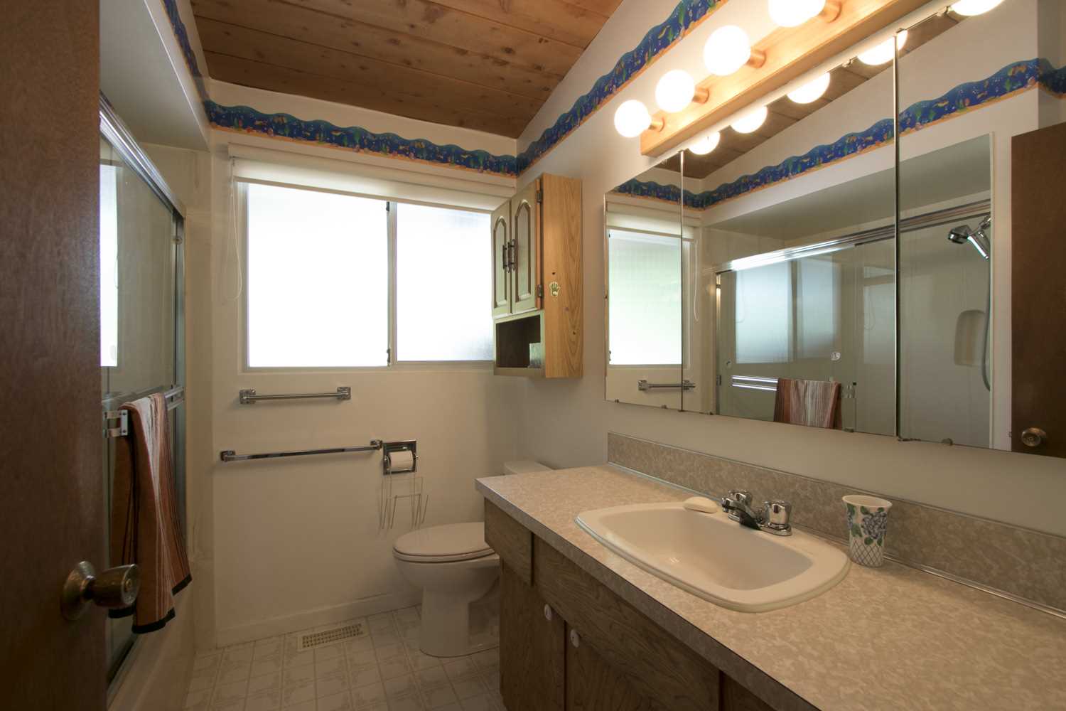 BEFORE - A dated bathroom with vinyl flooring.