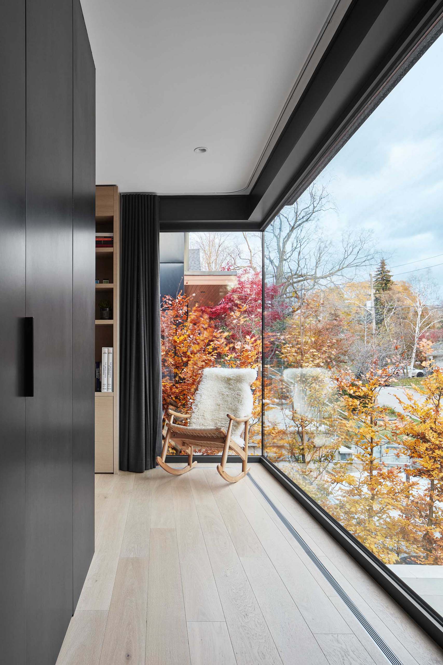 A large floor-to-ceiling corner window fills the space with natural light and provides views of the street.